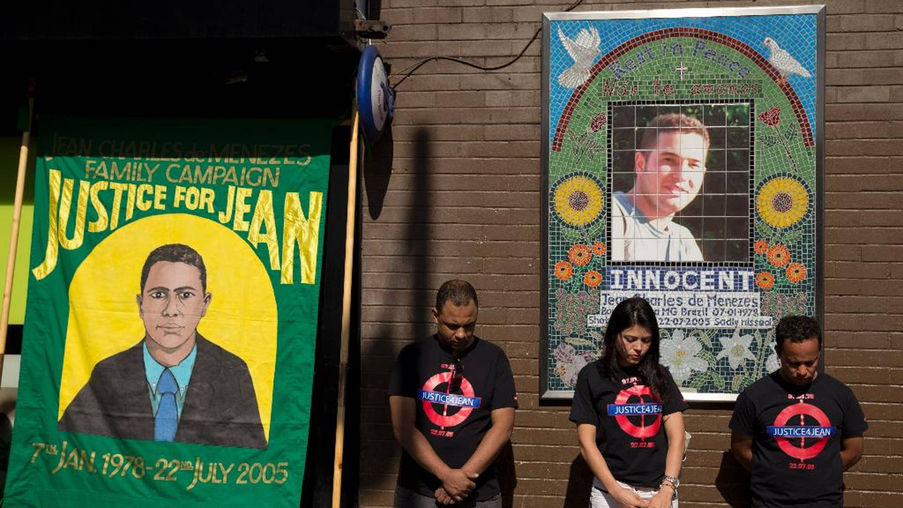 FILE - In this Wednesday, July 22, 2015 file photo, cousins Alessandro Pereira, right, Vivian Figueiredo and friend Erionaldo da Silva, left, observe a minute's silence on the 10-year-anniversary of the death of 27-year-old Brazilian electrician Jean Charles de Menezes, shot by British police, at Stockwell station in London. A European court on Wednesday, March 30, 2016 says British authorities were right not to prosecute police officers over the killing of a Brazilian man shot on the London Underground after being mistaken for a suicide bomber. The judgment by the European Court of Human Rights is a blow to relatives of Jean Charles de Menezes, who have sought for years to have police charged with his slaying. (AP Photo/Matt Dunham, file)