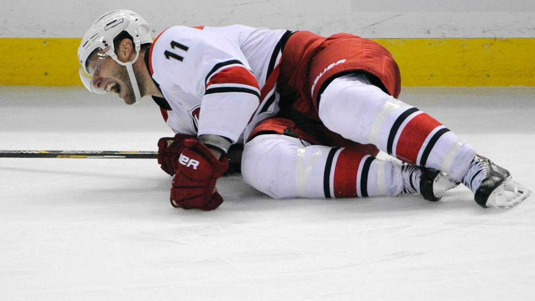 Carolina Hurricanes center Jordan Staal grimaces as he lays on the ice during the third period action of an NHL hockey preseason game against the Buffalo Sabres, Tuesday, Sept. 23, 2014, in Buffalo, N.Y. (AP Photo/Gary Wiepert)