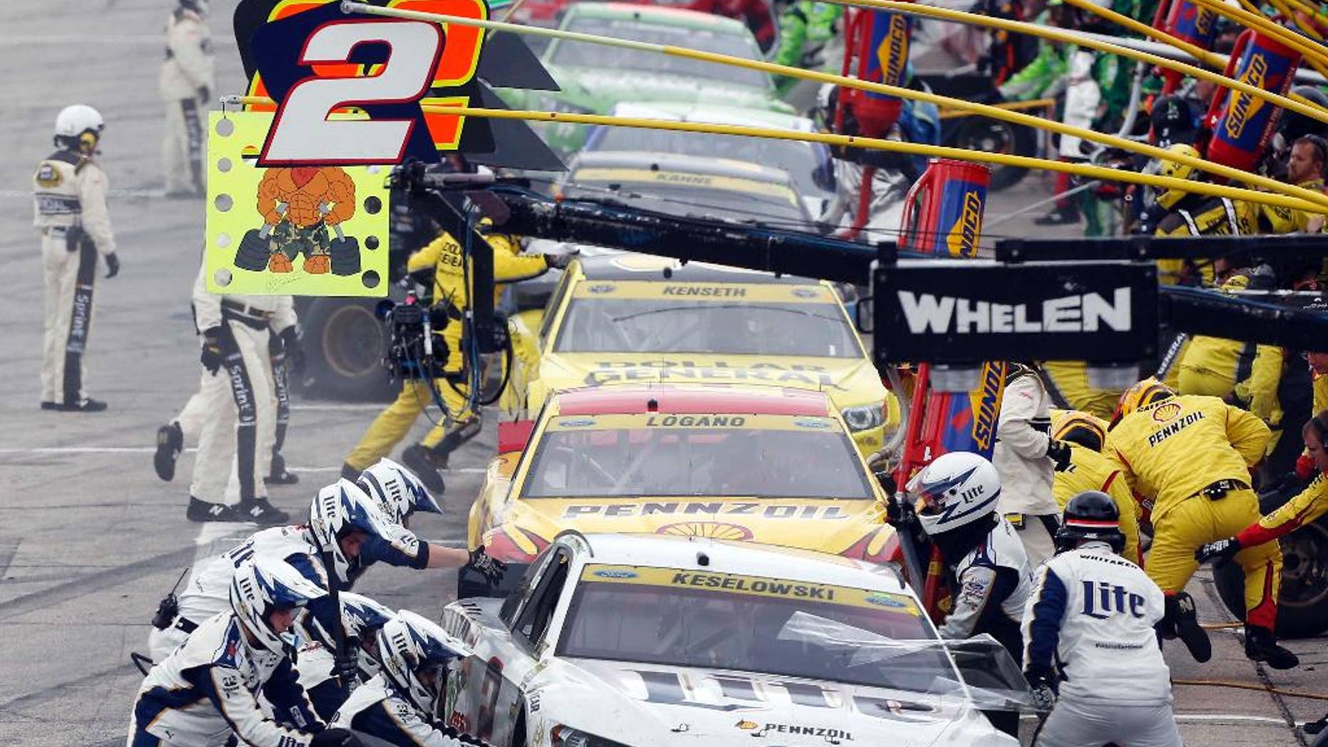 Brad Keselowski (2) leads cars in pit row during the NASCAR Sprint Cup series auto race at New Hampshire Motor Speedway, Sunday, Sept. 21, 2014, in Loudon, N.H. (AP Photo/Jim Cole)
