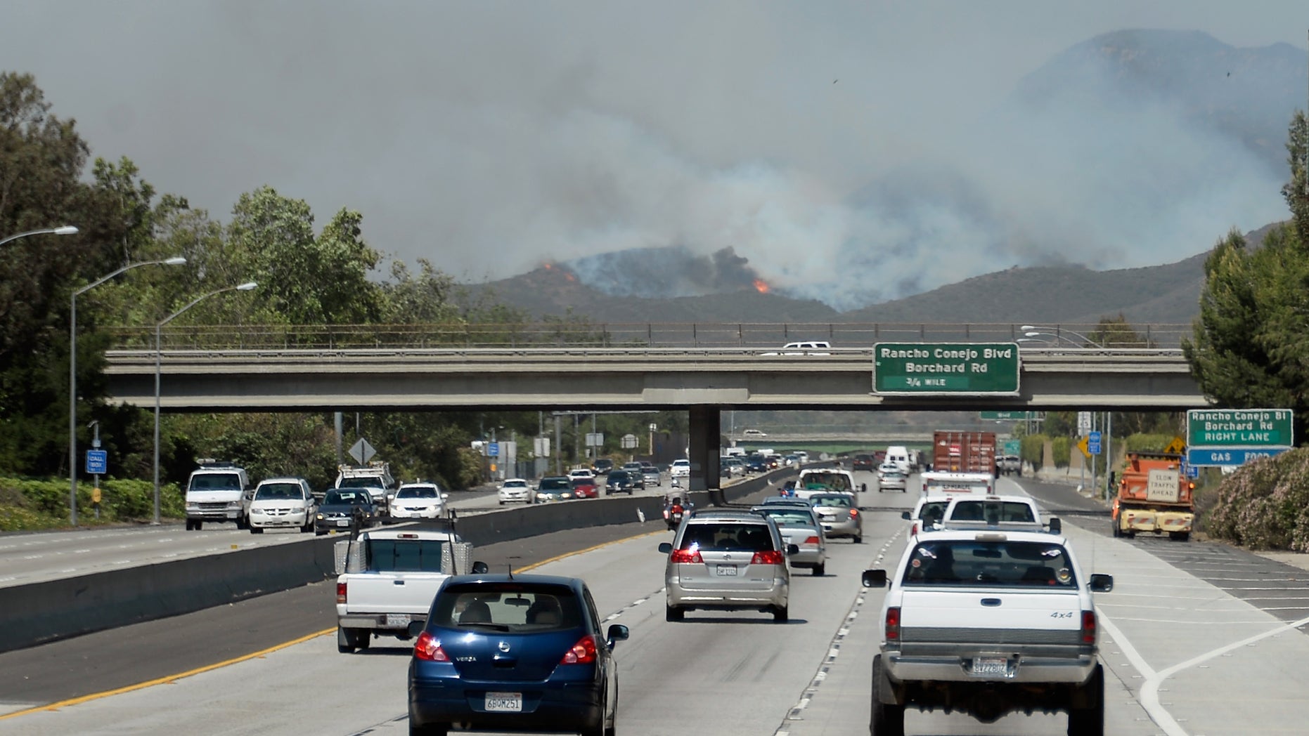 NEWBURY PARK, CA - MAY 02: Cars travel on the 101 Freeway as a wildfire burns in the hills nearby on May 2, 2013 in Newbury Park, California. Winds have made fighting the blaze, called the Springs Fire, more difficult and authorities have ordered some mandatory evacuations in the area. (Photo by Kevork Djansezian/Getty Images)