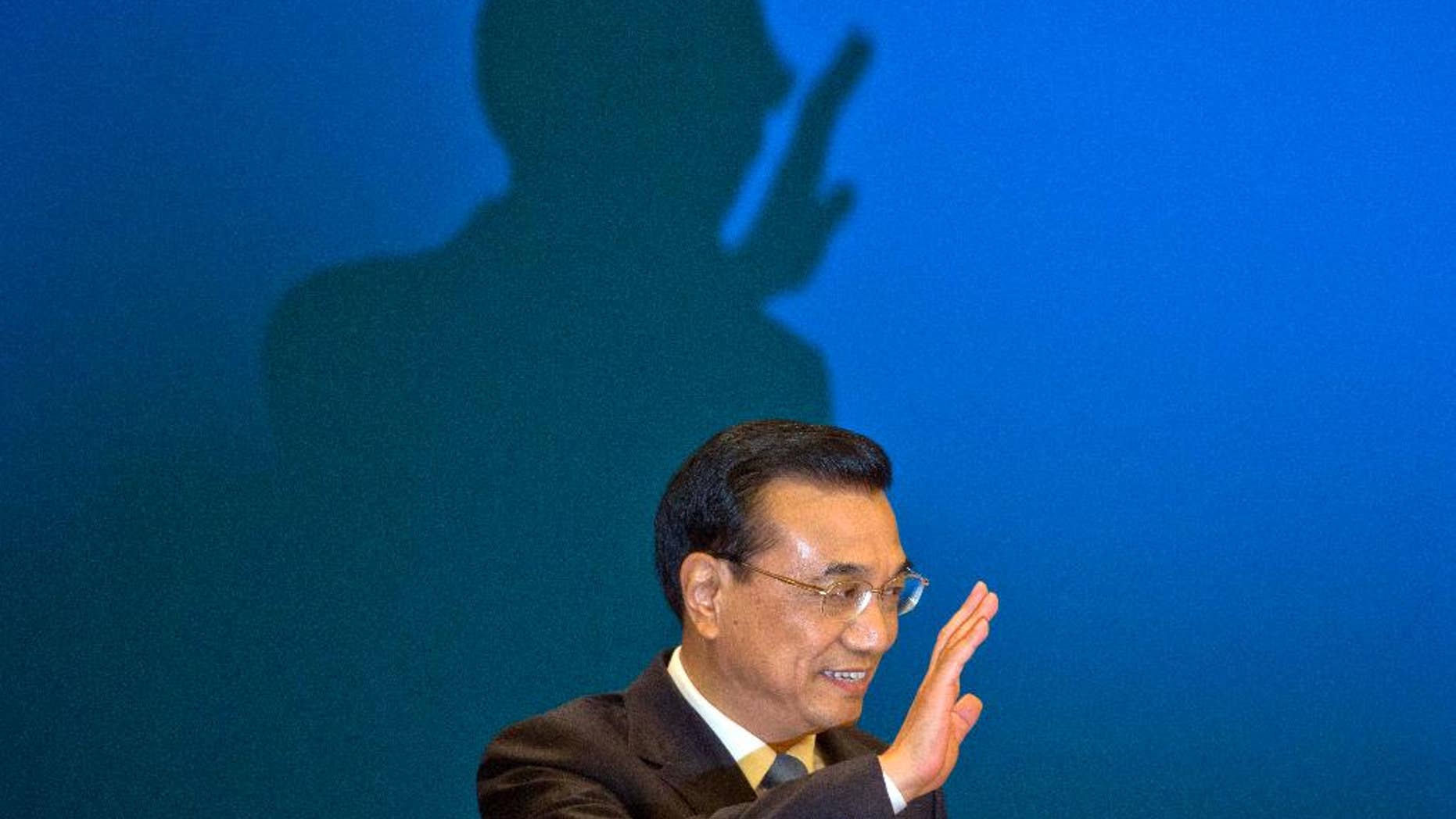 FILE - In this March 15, 2015, file photlo, Chinese Premier Li Keqiang waves as he arrives for a press conference at the end of the National People's Congress in Beijing's Great Hall of the People. Li Keqiang will accelerate plans for an ambitious railway linking Brazil’s Atlantic coast with a Pacific port in Peru, and announce billions in other investments and trade deals, when he visits Brasilia on Tuesday, May 19, 2015, kicking off a four-nation South American tour that includes Chile, Peru and Colombia. (AP Photo/Ng Han Guan, File)