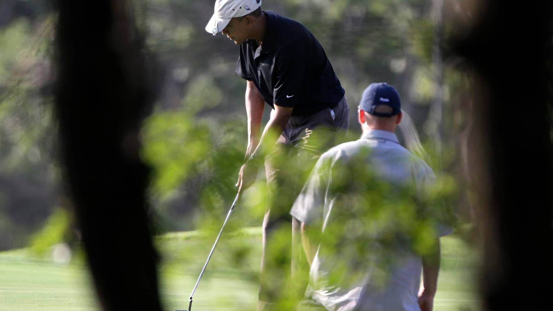 Friday: President Obama prepares to putt while playing golf at the Vineyard Golf Club, in Edgartown, Mass., on the island of Martha's Vineyard. The president is vacationing on the island with his family. (AP Photo)
