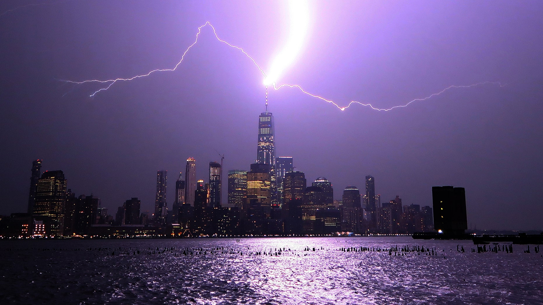 HOBOKEN, NJ - AUGUST 22: Lightning lights up the sky over lower Manhattan as a bolt strikes One World Trade Center in New York City on August 22, 2017 as seen from Hoboken, New Jersey. (Photo by Gary Hershorn/Getty Images)