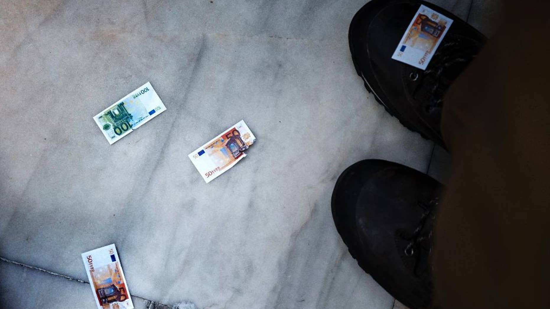 Pro-Euro demonstrators drop fake Euro notes during a rally outside the Greek Parliament in Athens, Monday, June 22, 2015. Thousands of people gather to show support for the country's future in the eurozone and the European Union. (AP Photo/Daniel Ochoa de Olza)