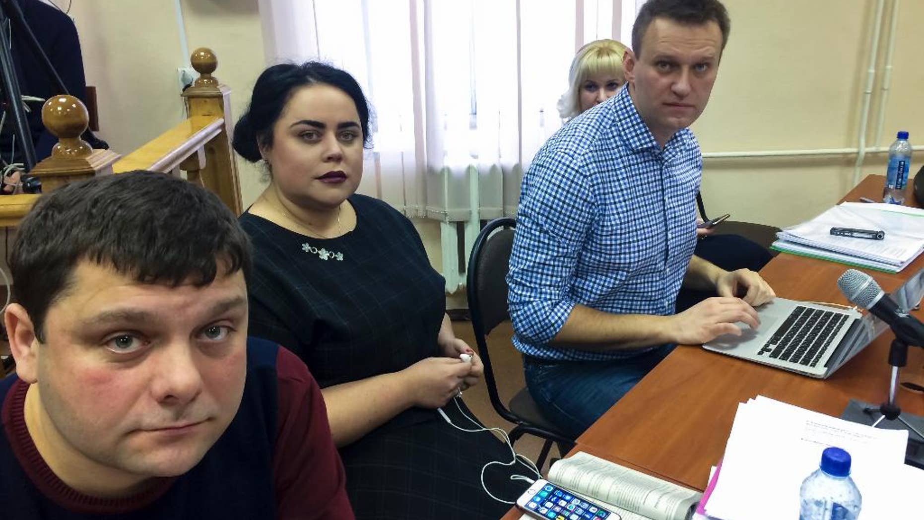 In this handout photo provided by Alexei Navalny press service Russian opposition leader Alexei Navalny, right, his former colleague Pyotr Ofitserov, left, and lawyer Svetlana Davydov, second left, sit in a courtroom in Kirov, Russia, Wednesday, Feb. 1, 2017. A retrial of Alexei Navalny for alleged embezzlement continues in the provincial city of Kirov after the original 2013 guilty verdict was overturned by the Supreme Court. (Alexei Navalny Press Service via AP)