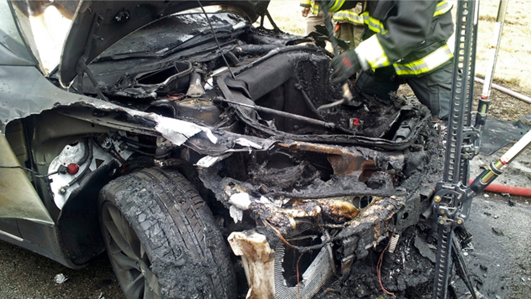 In this Wednesday, Nov. 6, 2013 photo provided by the Tennessee Highway Patrol, emergency workers respond to a fire on a Tesla Model S electric car in Smyrna, Tenn. Spokeswoman Liz Jarvis Shean says Tesla has sent a team to Tennessee to investigate the fire. Two other Model S cars have caught fire in the past five weeks, one near Seattle and the other in Mexico. (AP Photo/Tennessee Highway Patrol)