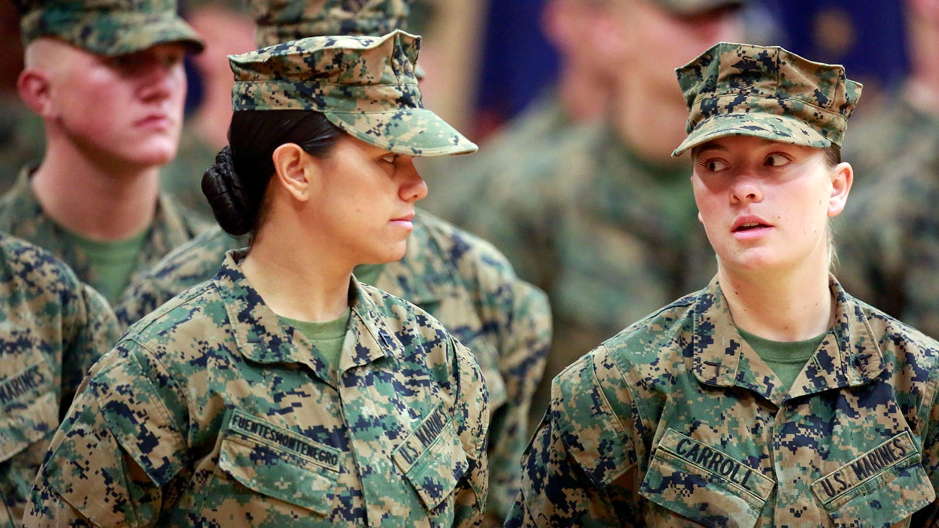 Private First Class Cristina Fuentes Montenegro, 25, left, shares a moment with Pfc. Julia Carroll, 18, during graduation ceremony held on Camp Geiger, Jacksonville, Thursday, Nov. 21, 2013. Montenegro and Carroll were two of the three female Marines who became the first women to graduate from the Corps' tough-as-nails enlisted infantry training school in North Carolina. The three completed the rigorous 59-day course and met the same test standards as the men, said Marine Corps spokeswoman Capt. Geraldine Carey. (AP Photo/The Daily News, John Althouse)
