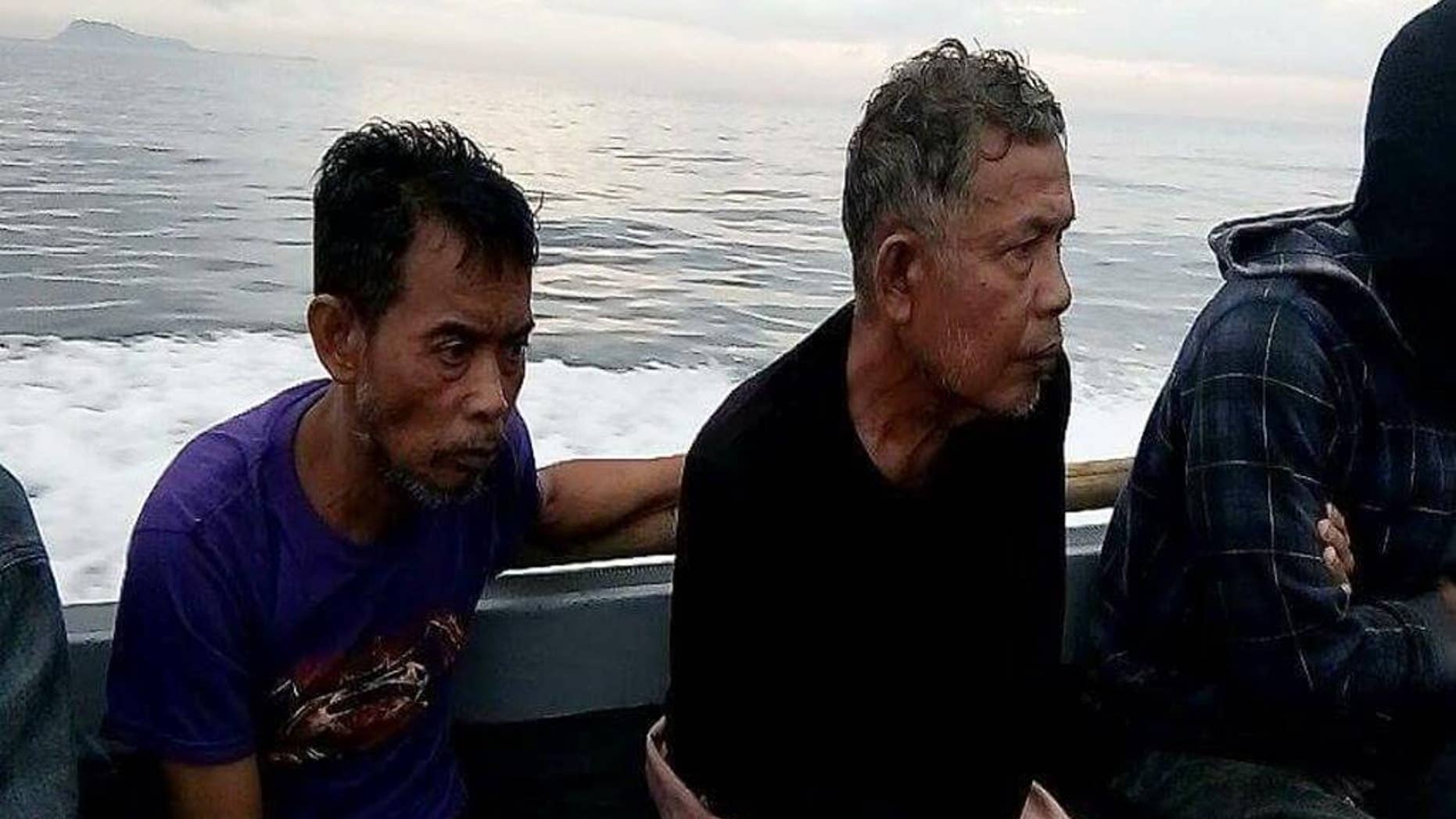 This photo provided by the Command Public Information Office, Western Mindanao Command, Malaysian hostages Tayudin Anjut, left, and Abdurahim Bin Sumas ride a boat after being rescued by marines in Sulu province, southern Philippines on Thursday March 23, 2017. Two Malaysian sailors held captive for eight months by Muslim militants were rescued Thursday in the southern Philippines, military officials said. (Command Public Information Office, Western Mindanao Command via AP)