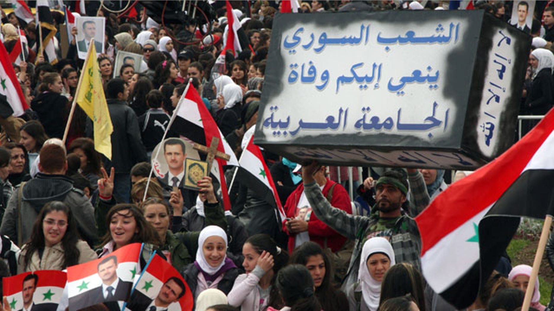 Nov. 24: Pro-Syrian regime protesters shout slogans as one holds a mock coffin with Arabic words reading: 'The Syrian people announce to you the death of the Arab League,' during a protest against the Arab League meeting, in Damascus, Syria.
