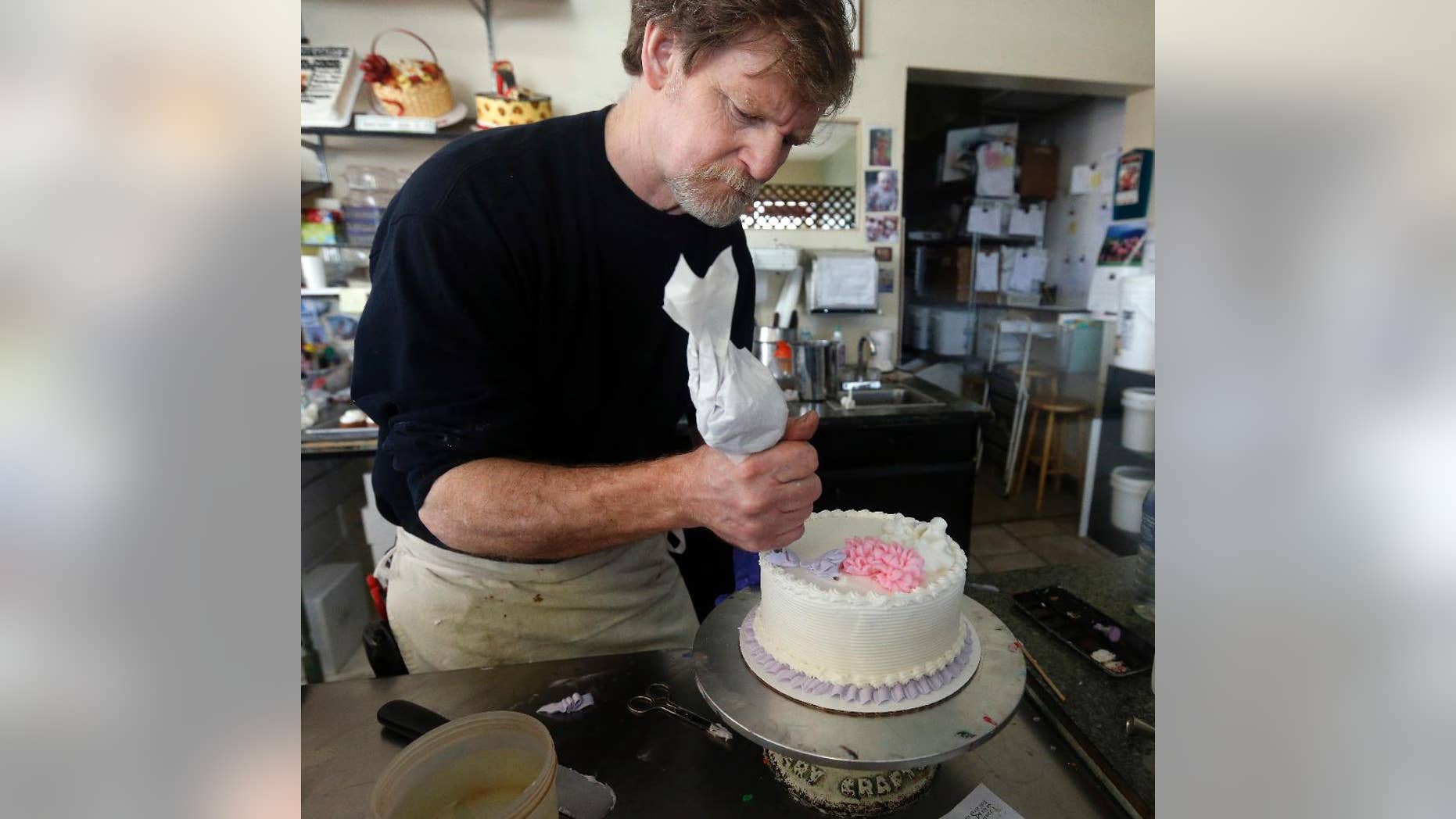 Masterpiece Cakeshop owner Jack Phillips decorates a cake inside his store, in Lakewood, Colo.