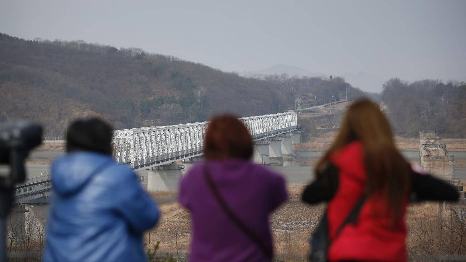 FILE - In this Friday, March 18, 2016, file photo, visitors look at the northern side at the Imjingak Pavilion near the border with North Korea, in Paju, South Korea. North Korea fired a short-range projectile from an area near its eastern coast on Tuesday, March 29, 2016, South Korean officials said, in what appears to be another weapons test seen as a response to ongoing military drills between Washington and Seoul.(AP Photo/Lee Jin-man)