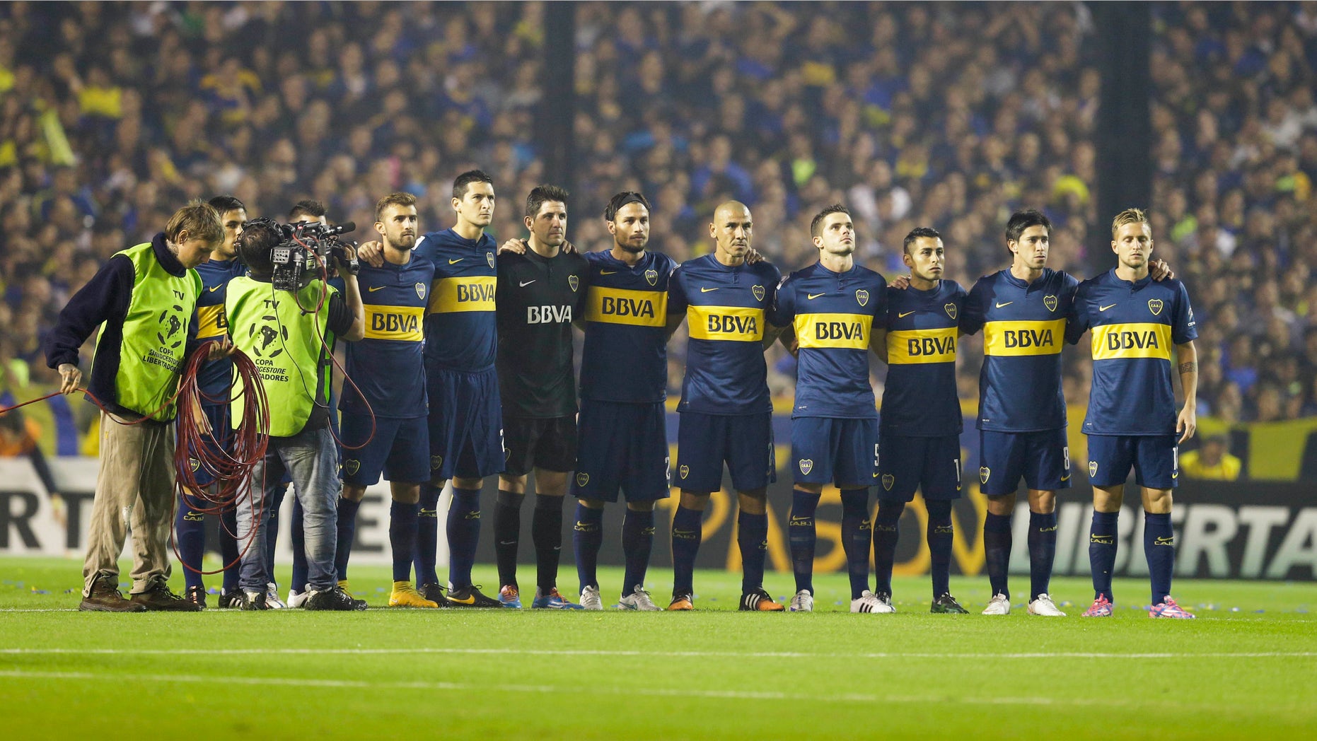 Argentina's Boca Juniors' players hold a minute of silence, in memory of an Argentine player who died earlier in the day, before a Copa Libertadores soccer match against River Plate in Buenos Aires, Argentina, Thursday, May 14, 2015. Emanuel Ortega, a 21-year-old fourth division soccer player, died after he was pushed by an opponent, and fell on concrete pillar during a fourth division game on May 3. Ortega died from his injury on Thursday. (AP Photo/Victor R. Caivano)