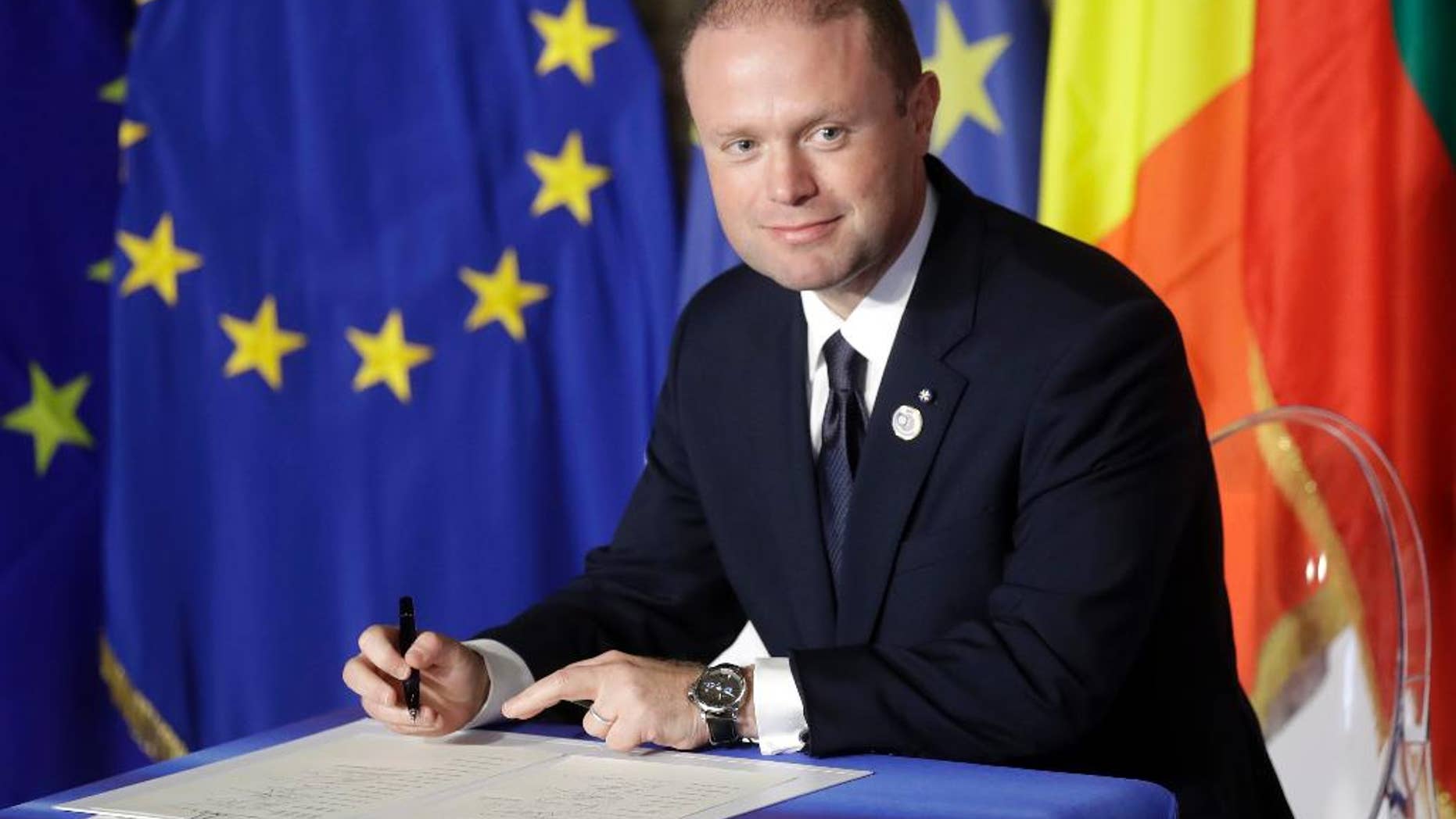 FILE - In this Saturday, March 25, 2017 file photo, Malta's Prime Minister Joseph Muscat signs a declaration during an EU summit meeting in the Palazzo dei Conservatori in Rome. Malta’s Prime Minister Joseph Muscat has called elections for June 3, a year early, to test his popularity amid a scandal swirling around his family. With the announcement on Monday, May 1, Muscat defied opposition demands for his resignation. (AP Photo/Alessandra Tarantino, file)