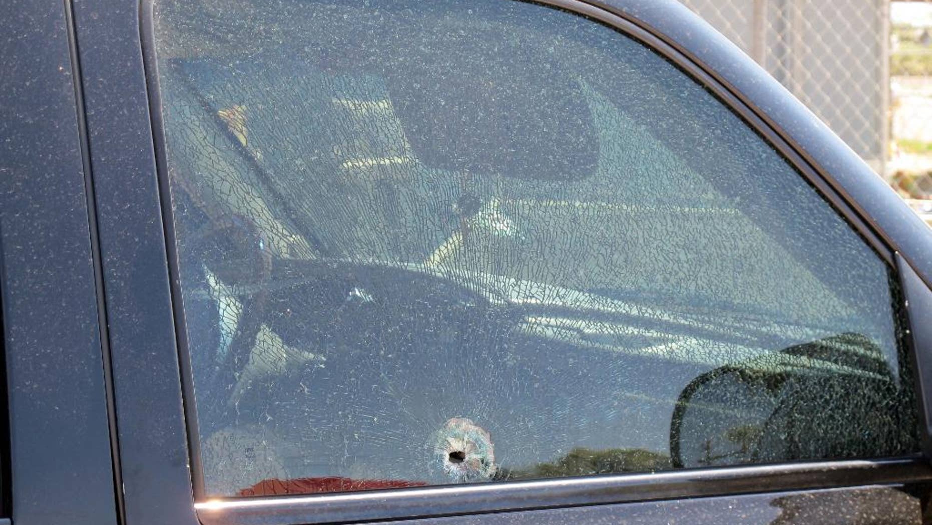 This Saturday, Aug. 29, 2015 photo provided by The Arizona Department of Public Safety shows a SUV window shattered by a gun shot in Phoenix. Authorities say shots were fired at several vehicles on Interstate 10 in Phoenix over the weekend, with bullets striking three vehicles and injuring one person. (The Arizona Department of Public Safety via AP)