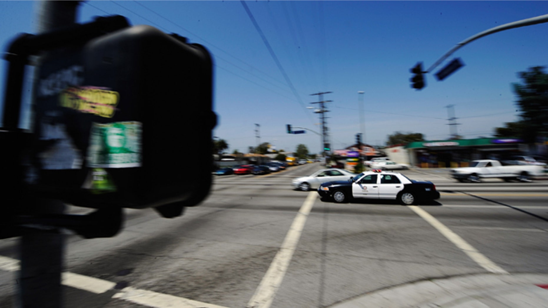 LOS ANGELES, CA - APRIL 27: A Los Angeles Police Department car with lights and sirens going rushes through the intersection at Florence and Normandy Avenues in South Los Angeles on April 27, 2012 in Los Angeles, California. The intersection was the scene of the beating of truck driver Reginald Denny on April 29, 1992 during the early stages of the Los Angeles riots. Its been 20 years since the Rodney King verdict that sparked the riots. (Photo by Kevork Djansezian/Getty Images)