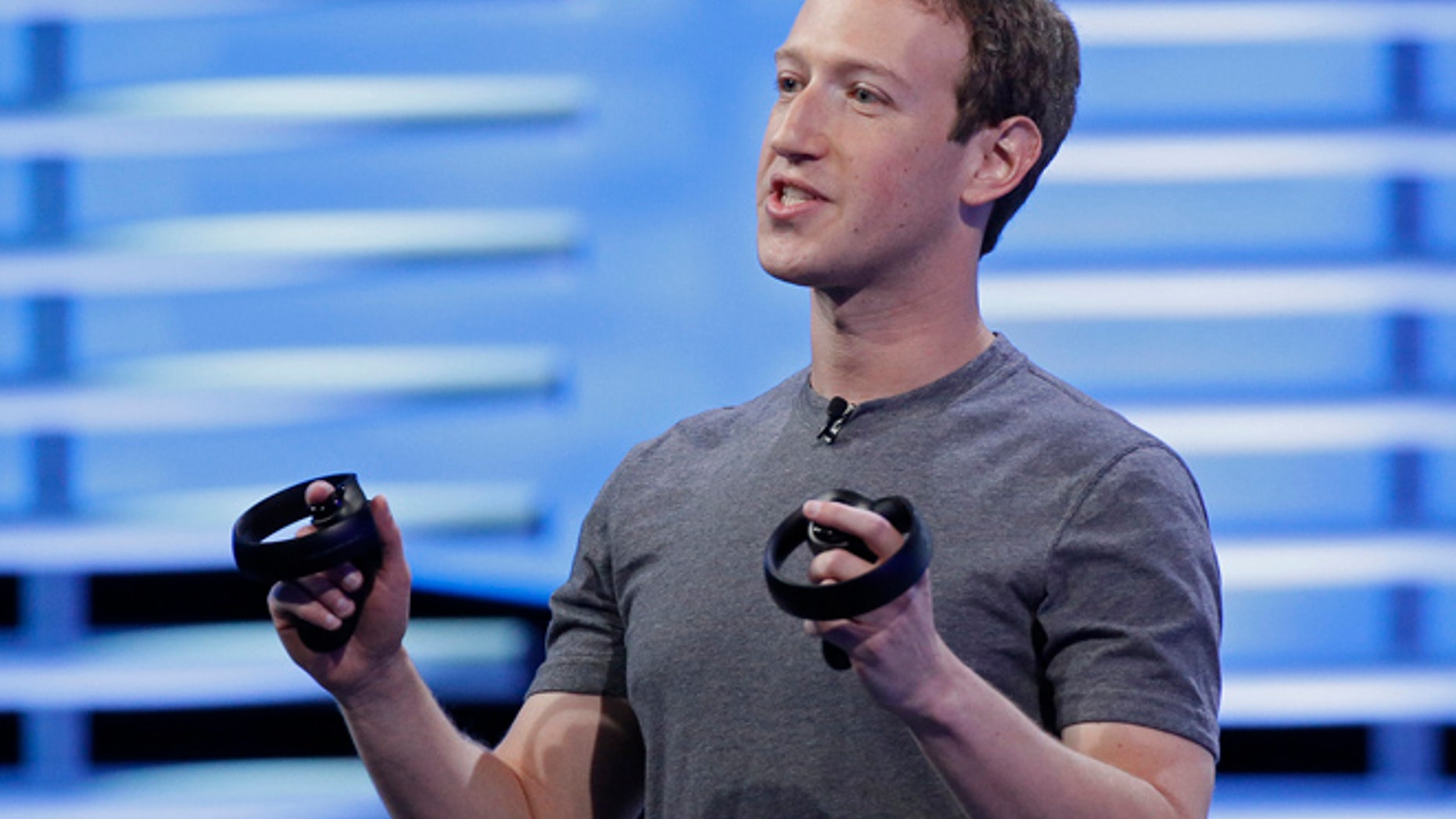 Facebook's Mark Zuckerberg holds a pair of virtual reality handsets in San Francisco