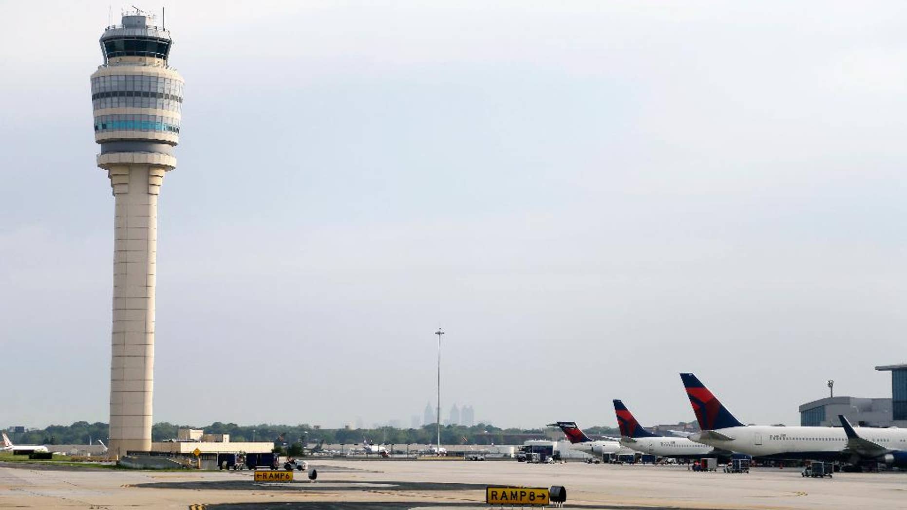 FILE- This May 9, 2016, file photo, shows an air traffic control tower at their gates at Hartsfield–Jackson Atlanta International Airport in Atlanta. With a broken throttle Cathy Lewan, the pilot of a small plane, found herself over the world’s busiest airport and facing calamity, but air traffic controllers guided her to a safe landing at Hartsfield-Jackson Atlanta International Airport on Feb. 14, 2016. On Tuesday, March 14, 2017, Lewan had a reunion with the Atlanta air traffic controllers who were her lifeline. (AP Photo/Mike Stewart, File)