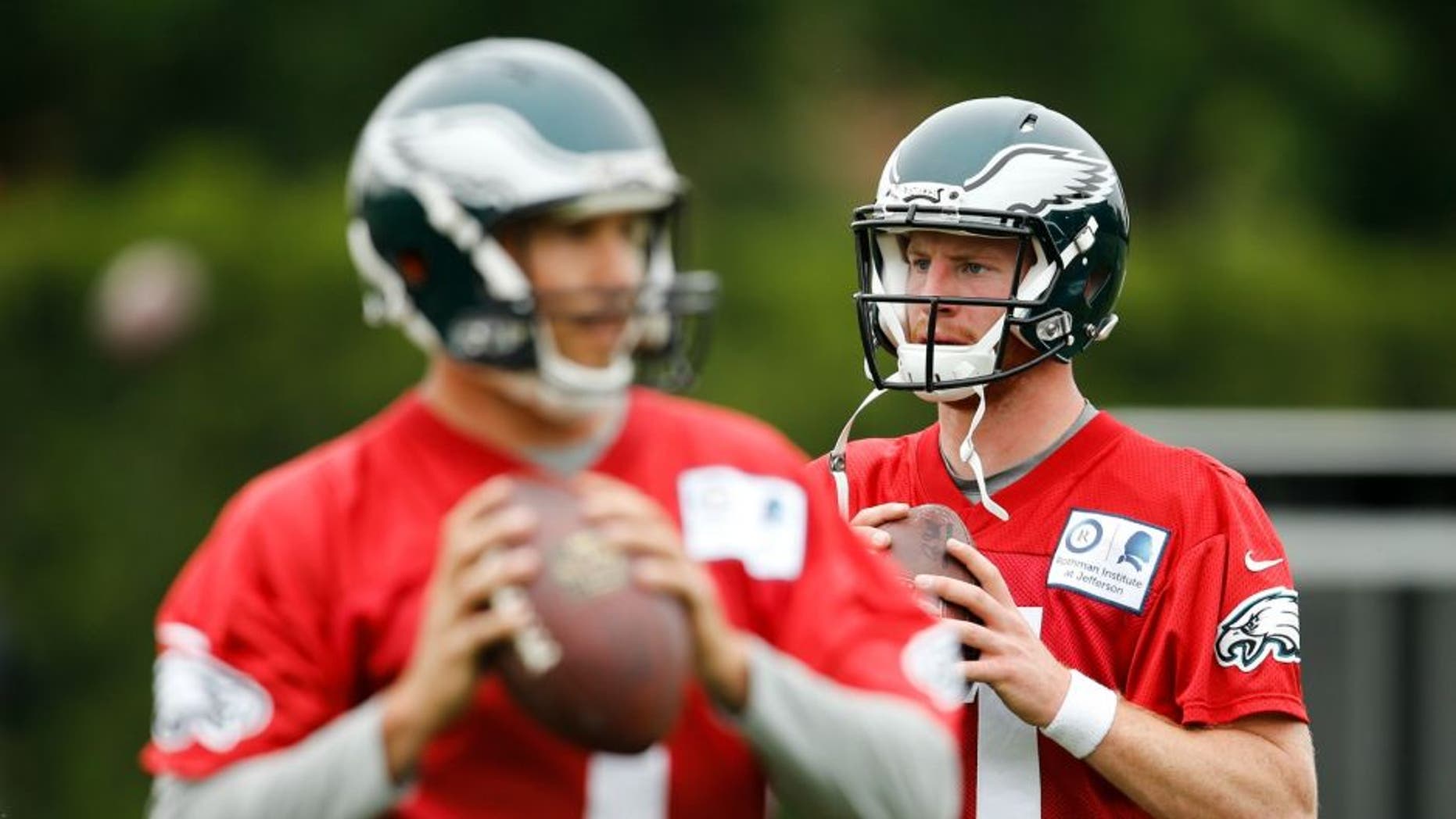 Philadelphia Eagles quarterbacks Sam Bradford, left, and Carson Wentz prepare to throw passes at the team's NFL football training facility, Tuesday, May 17, 2016, in Philadelphia. (AP Photo/Matt Rourke)