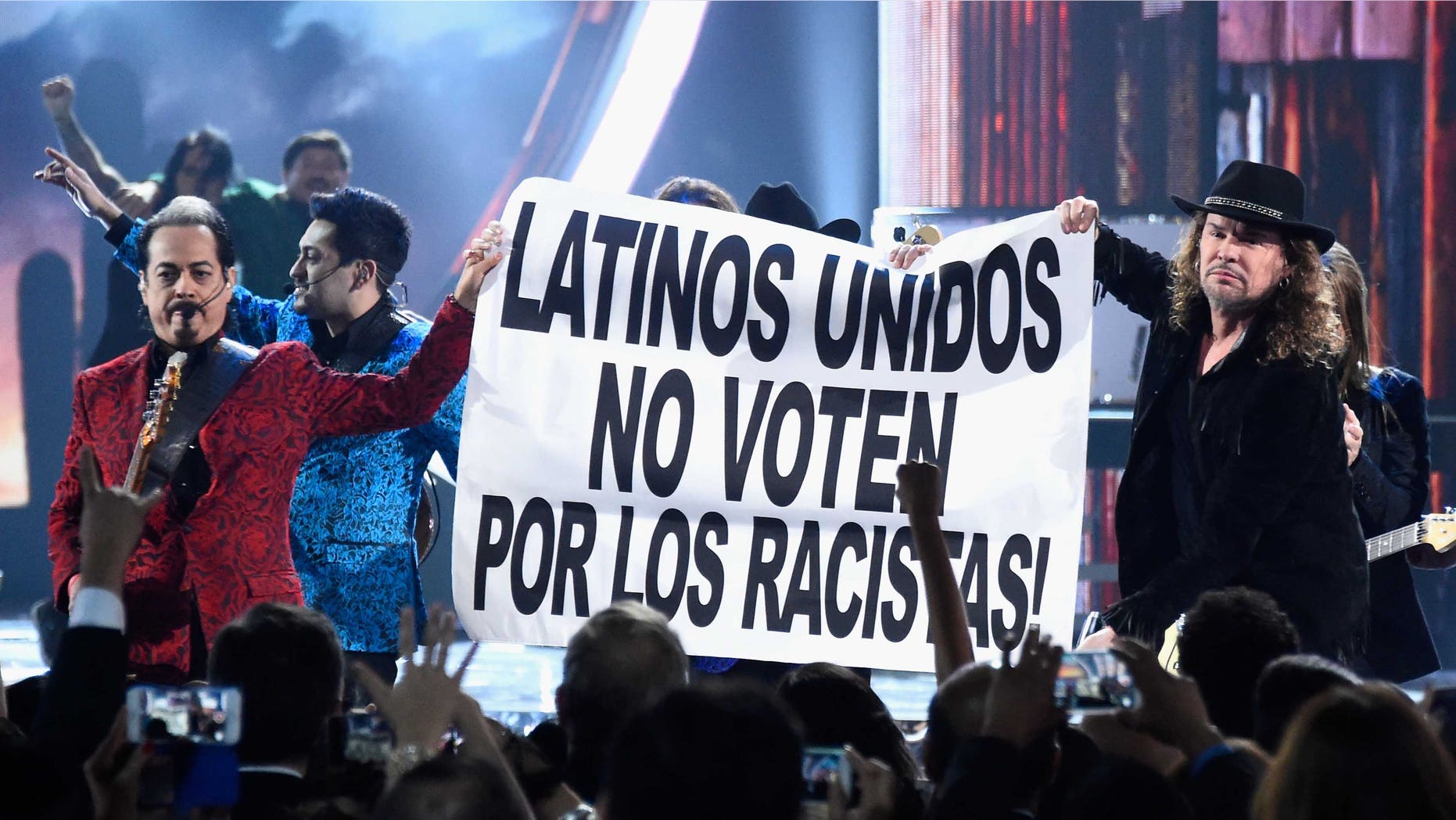 LAS VEGAS, NV - NOVEMBER 19: Members of the music groups Mana and Los Tigres Del Norte hold up a sign onstage during the 16th Latin GRAMMY Awards at the MGM Grand Garden Arena on November 19, 2015 in Las Vegas, Nevada. (Photo by Frazer Harrison/Getty Images for LARAS)
