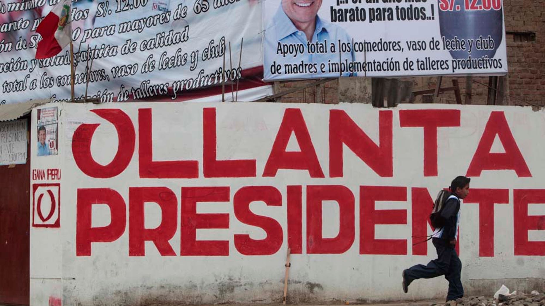 A boy runs in front of electoral propaganda of Peru's presidential candidate Ollanta Humala, of the Gana Peru party, in Lima, Peru, Monday, May 30, 2011. Humala will face Keiko Fujimori, daughter of former Peru's President Alberto Fujimori in a presidential runoff June 5. (AP Photo/Esteban Felix)