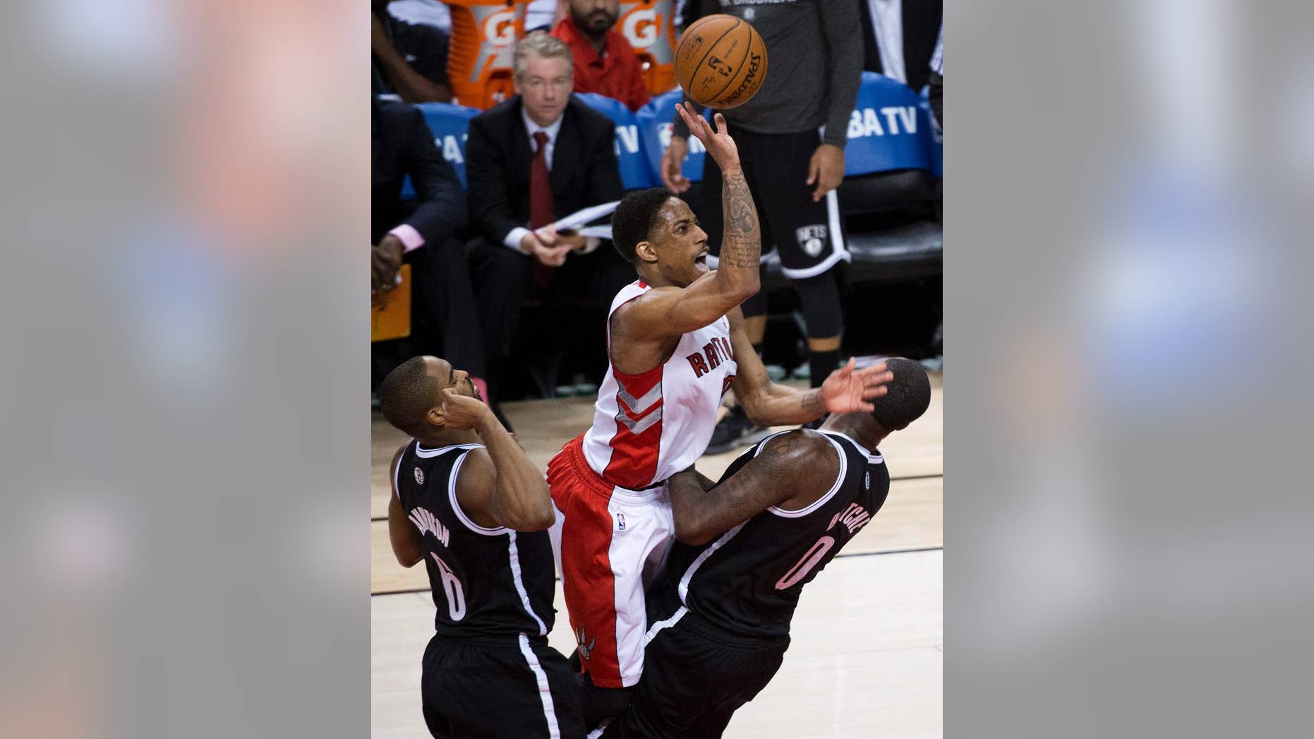 Toronto Raptors guard DeMar DeRozan, center, is charged with an offensive foul against Brooklyn Nets forward Andray Blatche as Nets forward Alan Anderson, left, looks on during the second half of Game 7 of the opening-round NBA basketball playoff series in Toronto, Sunday, May 4, 2014. (AP Photo/The Canadian Press, Nathan Denette)