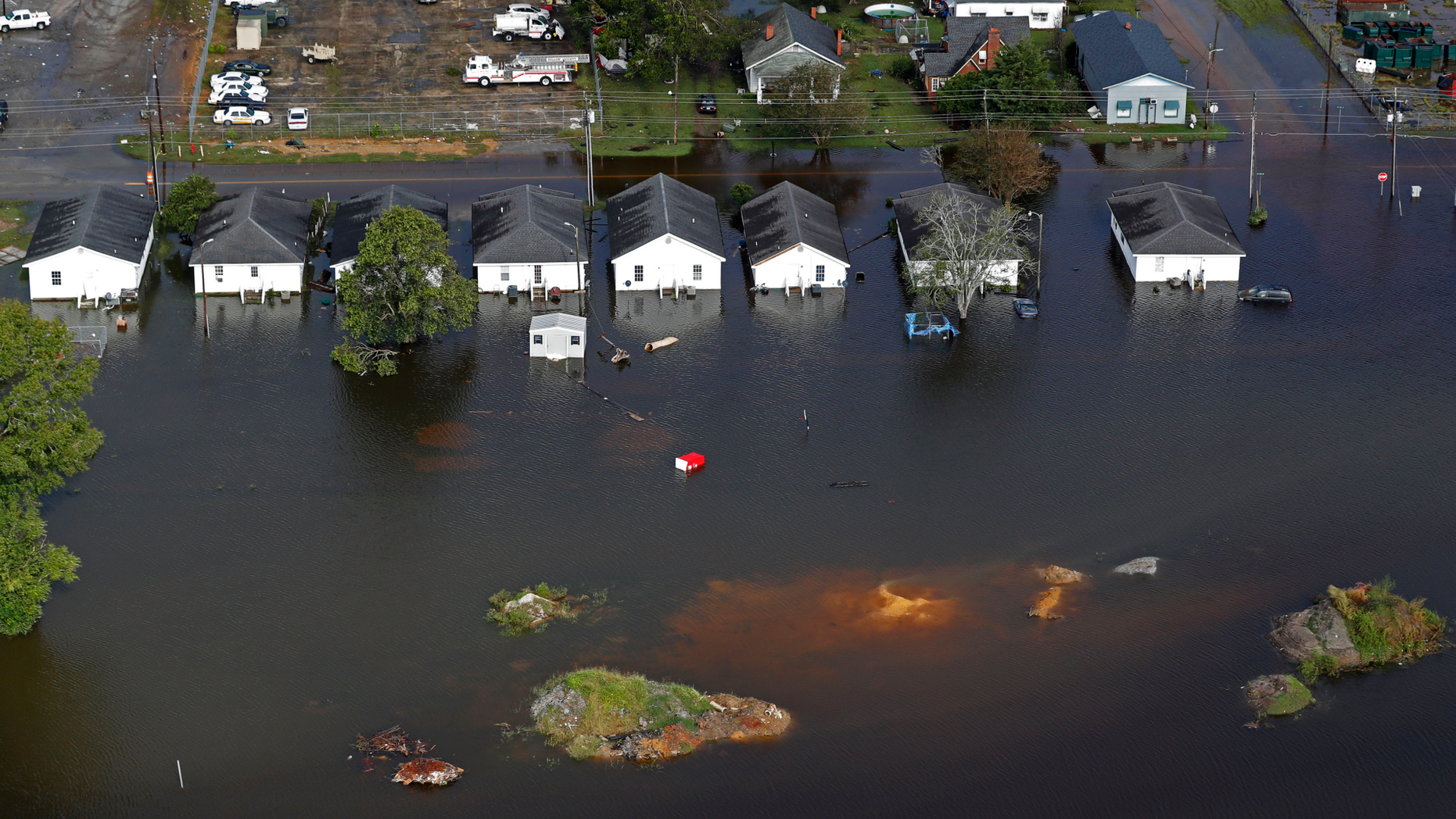 FILE - In this Monday, Sept. 17, 2018 file photo, floodwaters from Hurricane Florence surrounds homes in Dillon, S.C. Scientists say climate change likely boosted rainfall totals for both Florence and 2017's Harvey. (AP Photo/Gerald Herbert)