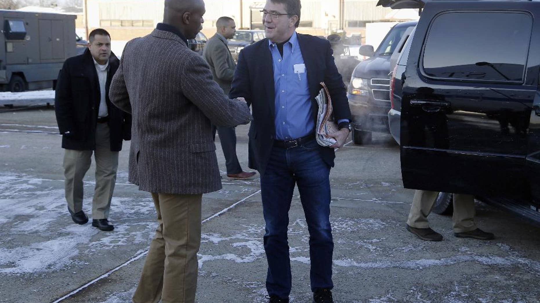 FILE - In this Feb. 20, 2015, file photo, U.S. Secretary of Defense Ash Carter, center, is greeted by Senior Military Assistant U.S. Army Maj. Gen. Ron Lewis as they arrive at Andrews Air Force Base, Md., to travel to Afghanistan. A Pentagon investigation concluded that Lewis, Carter's former senior military aide, used his government credit card at strip clubs or gentlemen's clubs in Rome and Seoul, drank in excess and had "improper interactions" with women, The Associated Press has learned. (Jonathan Ernst/Pool Photo via AP, File)