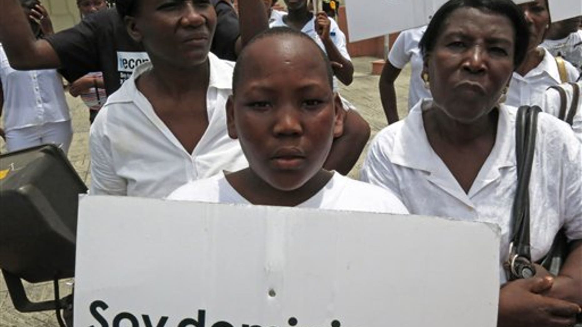 FILE - In this Aug. 12, 2013 file photo, a youth of Haitian descent holds a sign that reads in Spanish "I'm Dominican" during a protest demanding that President Danilo Medina stop the process to invalidate their birth certificates after authorities retained their ID cards, in Santo Domingo, Dominican Republic. The Dominican Republic's top court on Thursday, Sept. 26, 2013 stripped citizenship from thousands of people born to migrants who came illegally, a category that overwhelmingly includes Haitians brought in to work on farms. The decision cannot be appealed, and it affects all those born since 1929. (AP Photo/Ezequiel Abiu Lopez, File)