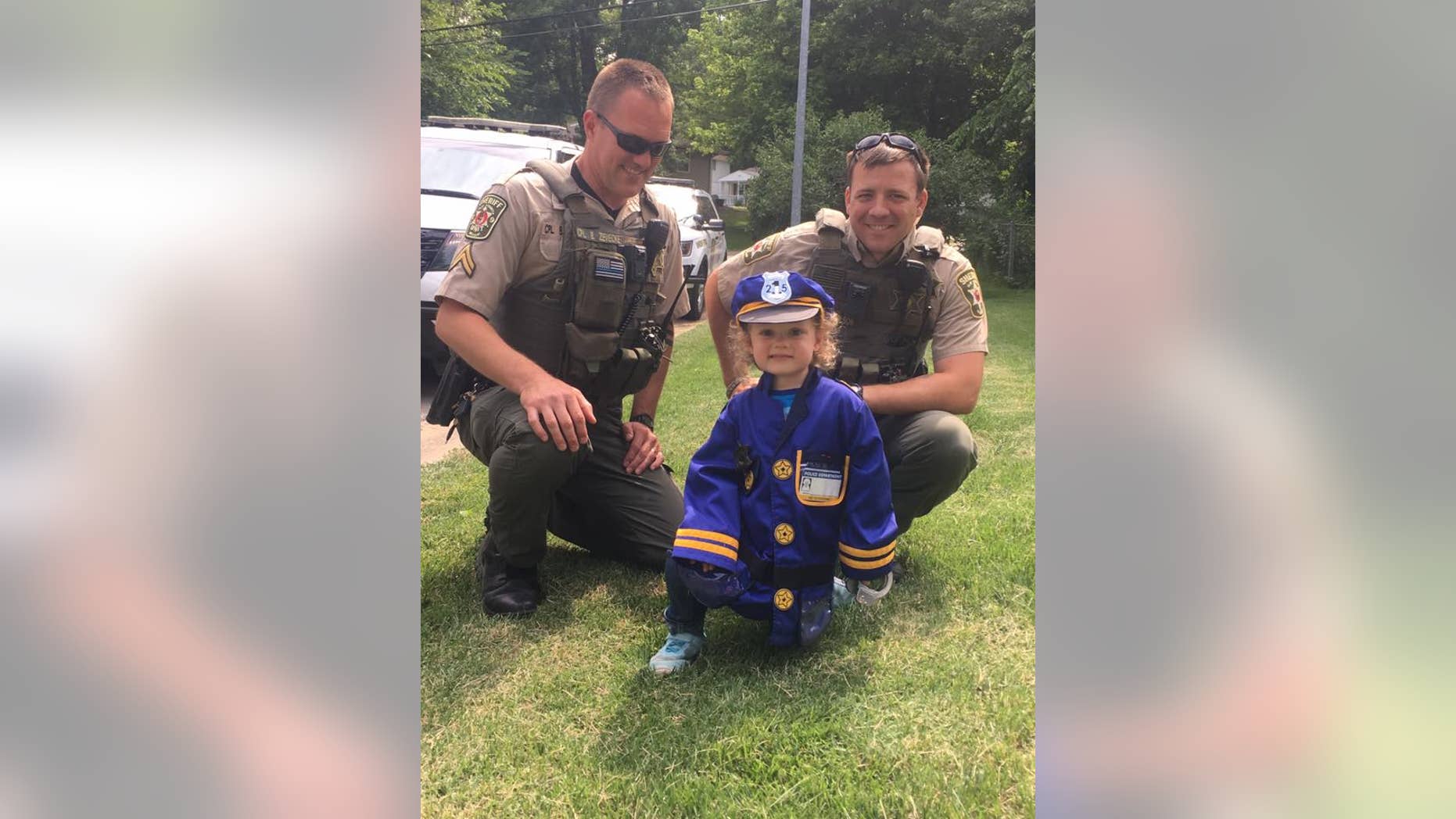 Kansas City police officers posing with Hannah Pasley in her new uniform.