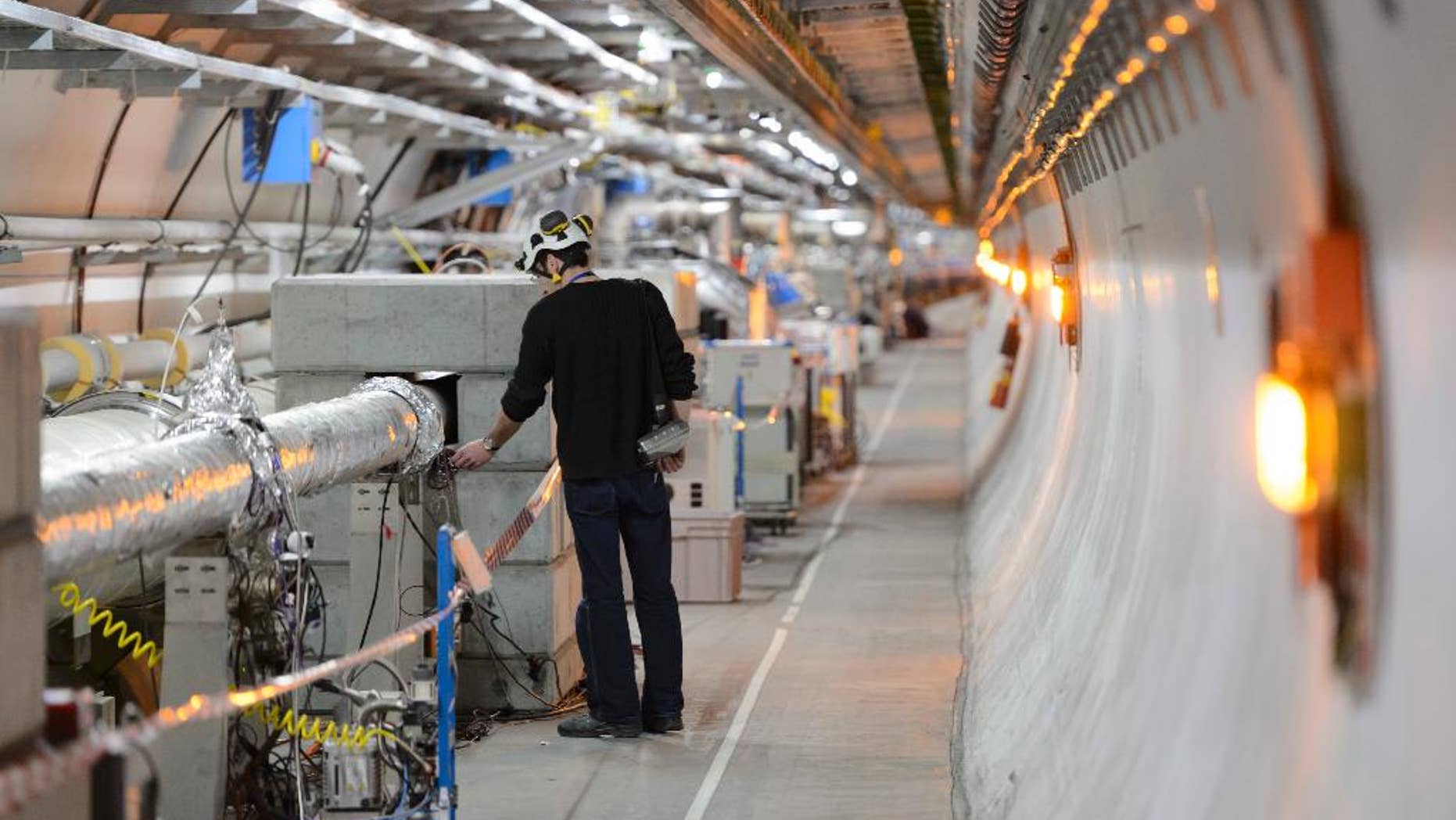 FILE - In this Feb. 16, 2016 file photo a technician works in the LHC (Large Hadron Collider) tunnel of the European Organization for Nuclear Research, CERN, during a press visit in Meyrin, near Geneva, Switzerland. Officials at CERN, home to the world’s largest particle accelerator, say they’ve launched an internal investigation over a “spoof” video filmed on its campus appearing to mimic a human sacrifice. (Laurent Gillieron/Keystone via AP, file)