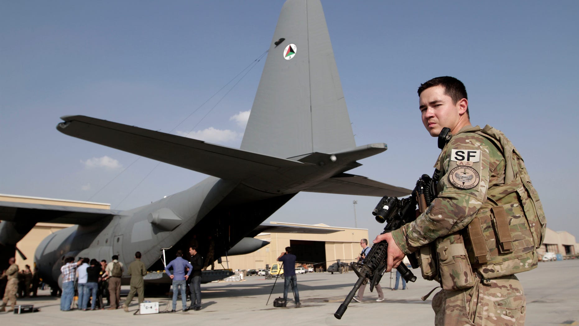 An International Security Assistance Force soldier stands guard near a C-130 transport aircraft at the Afghan Air Force Base in Kabul, Afghanistan, Wednesday, Oct. 9, 2013. Afghanistan took delivery on Wednesday of two C-130 transport aircraft from the United States, part of an effort to give the country’s military the ability to better fight insurgents around the country. (AP Photo/Rahmat Gul)