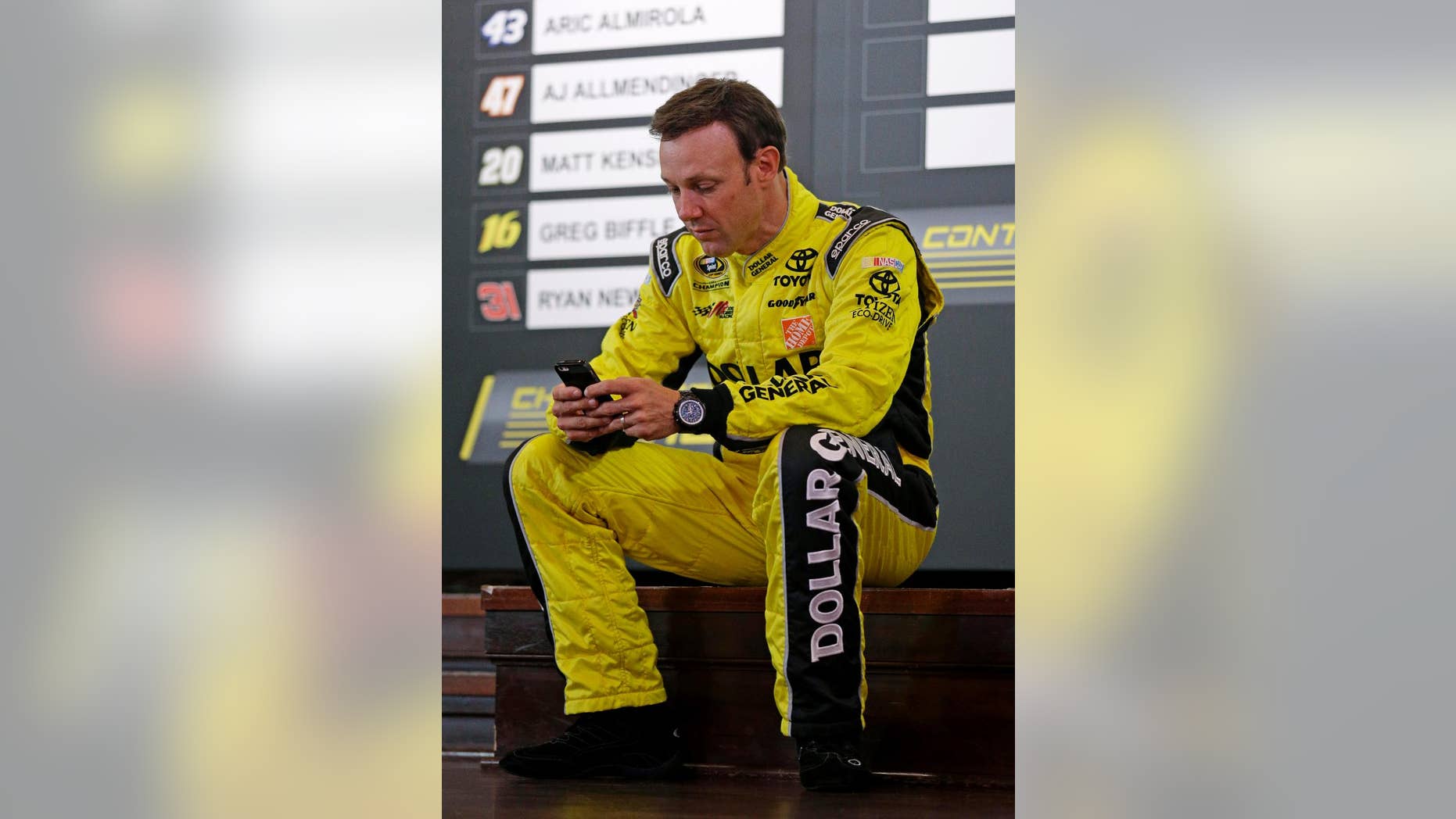 Matt Kenseth checks his phone during the NASCAR Sprint Cup media day in Chicago, Thursday, Sept. 11, 2014. The 16 drivers in the Chase for the Sprint Cup championship took part in the event. The opening race in the Chase is at Chicagoland Speedway on Sunday in Joliet, Ill. (AP Photo/Nam Y. Huh)