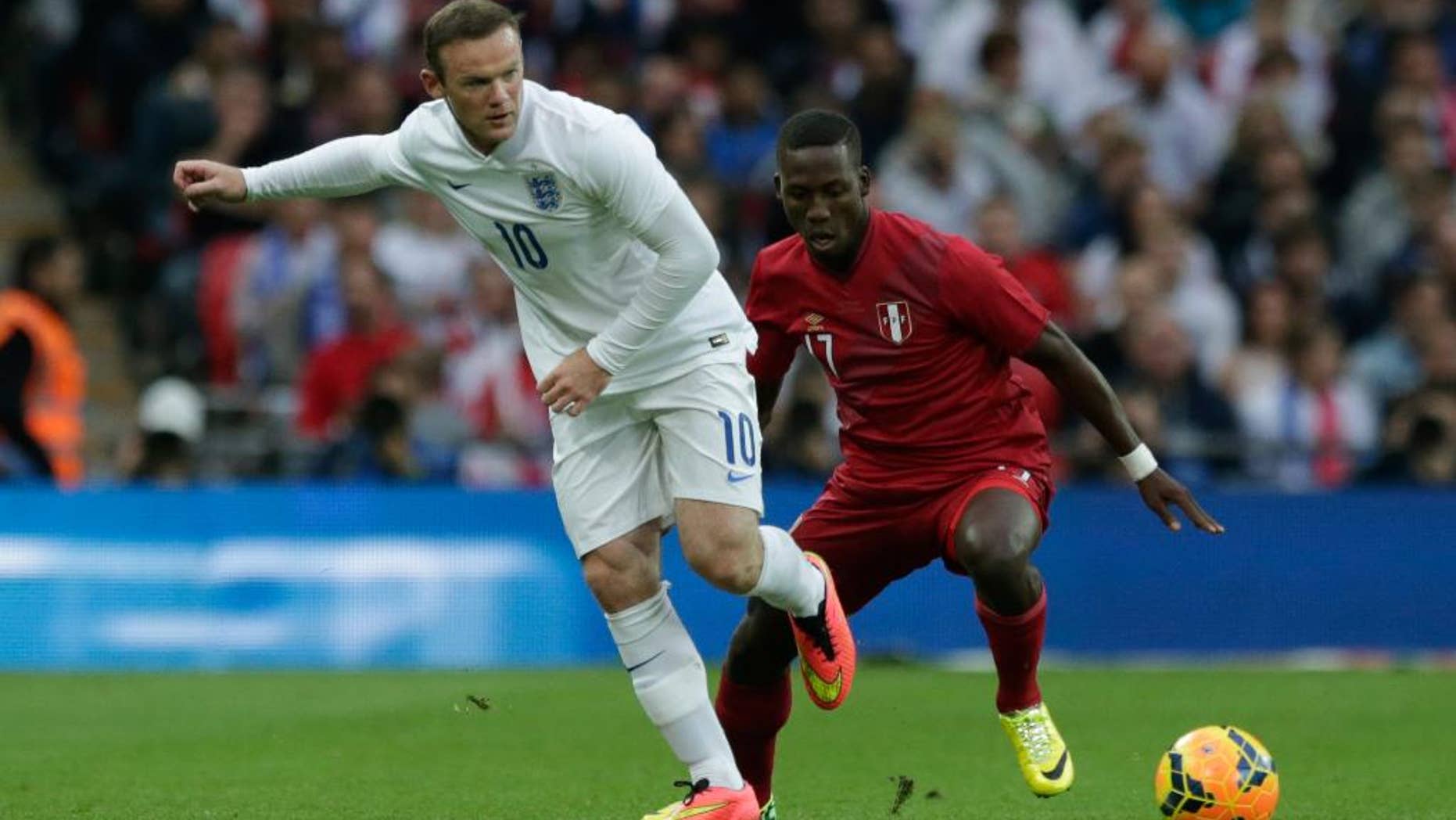 England's Wayne Rooney, left, competes for the ball with Peru's Luis Advincula during the international friendly soccer match between England and Peru at Wembley Stadium in London, Friday, May 30, 2014. (AP Photo/Matt Dunham)