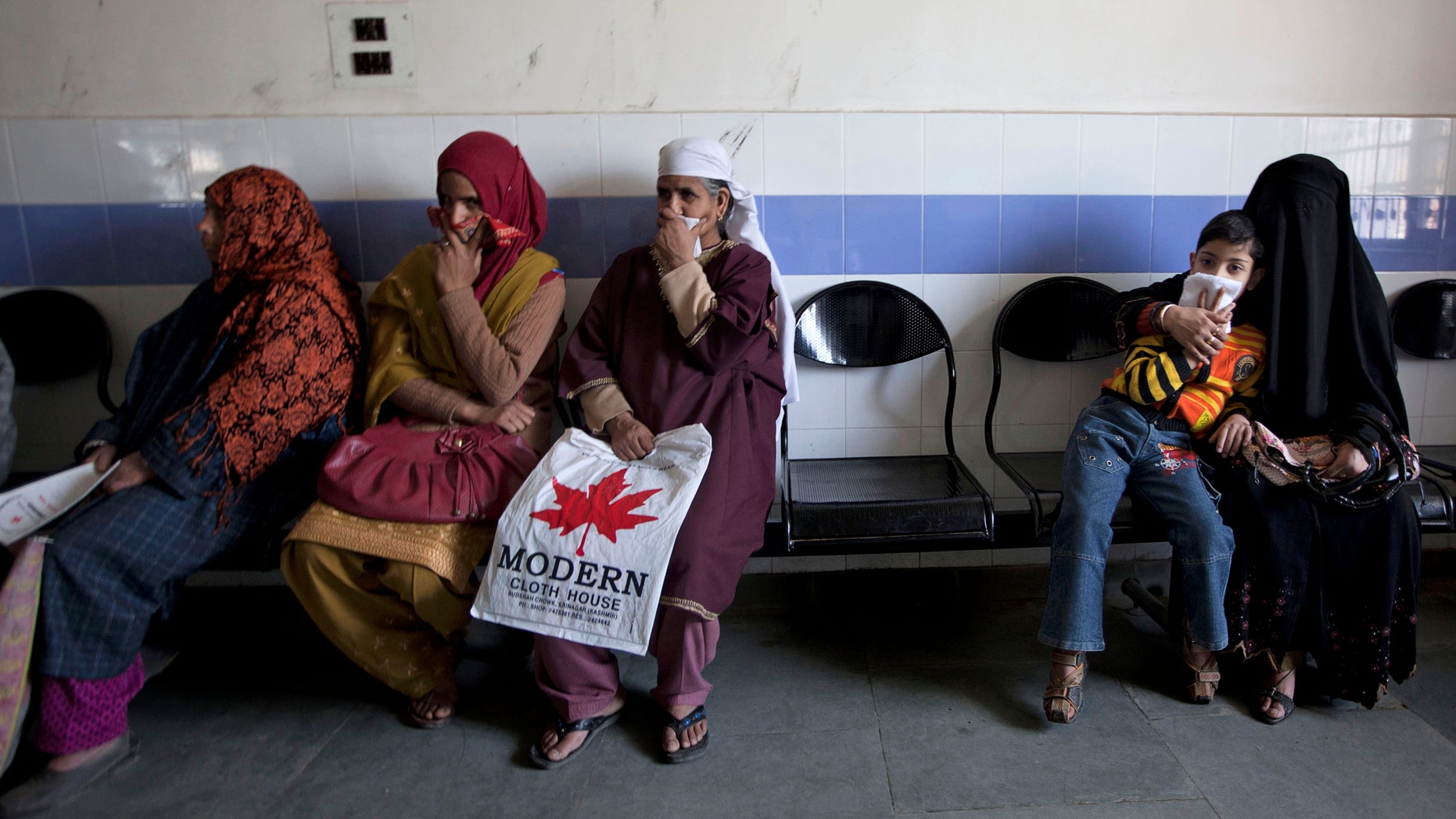 A child waits along with Kashmiri women for his turn to be examined at the Chest Disease Hospital on World Tuberculosis Day in Srinagar, India. Health officials are embarking on an ambitious plan to wipe out tuberculosis in children even though they don't know exactly how many cases there are.