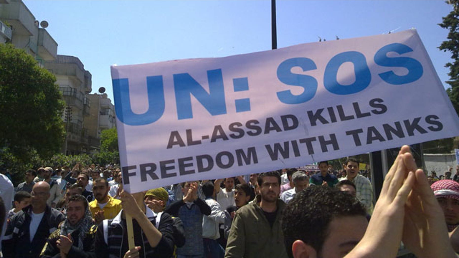 May 6: In this citizen journalism image made on a mobile phone and acquired by the AP, Syrian anti-government protesters carry a banner during a rally in the central city of Homs, Syria.