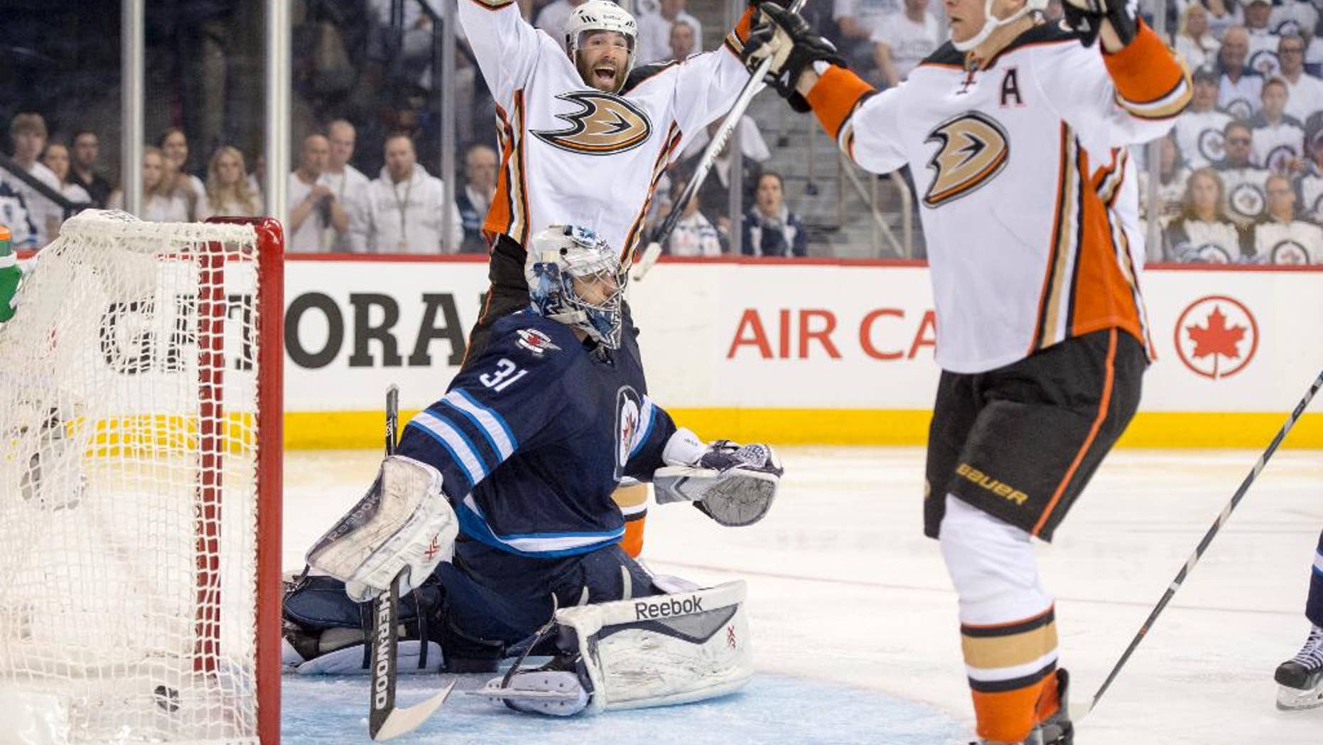 Anaheim Ducks left wing Patrick Maroon (19) and right wing Corey Perry (10) celebrate Perry's goal against Winnipeg Jets goalie Ondrej Pavelec (31) during the second period of Game 3 of the opening round of the Stanley Cup NHL hockey playoffs, Monday, April 20, 2015, in Winnipeg, Manitoba. Anaheim defeated Winnipeg 5-4 in overtime, taking a 3-0 series lead. (Michael Goulding/The Orange County Register via AP)