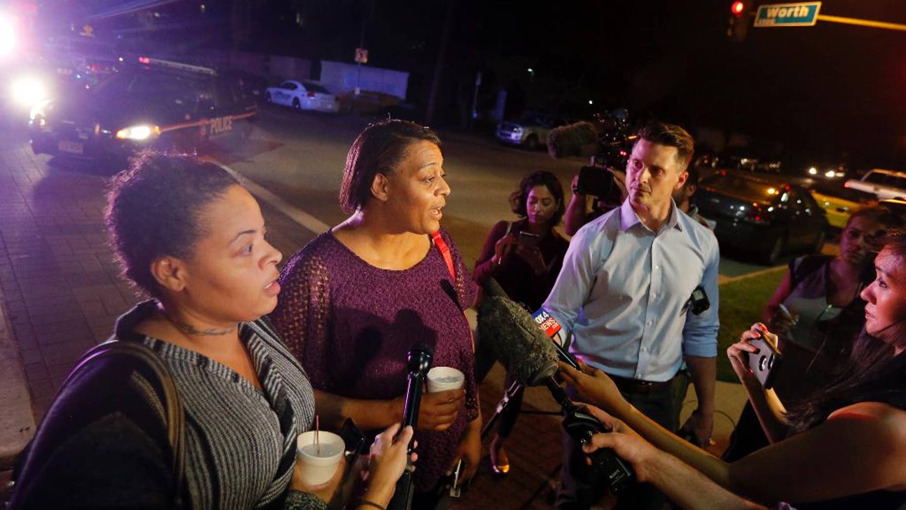 CORRECTS SPELLING TO SHERIE - Sherie Williams, left, and Theresa Williams, center, speak to the media as they leave the Baylor University Medical Center, Friday, July 8, 2016, in Dallas. Theresa Williams said her sister Shetamia Taylor, who was attending a rally with her four teenage sons in downtown Dallas, was shot in one of her legs. (AP Photo/Tony Gutierrez)