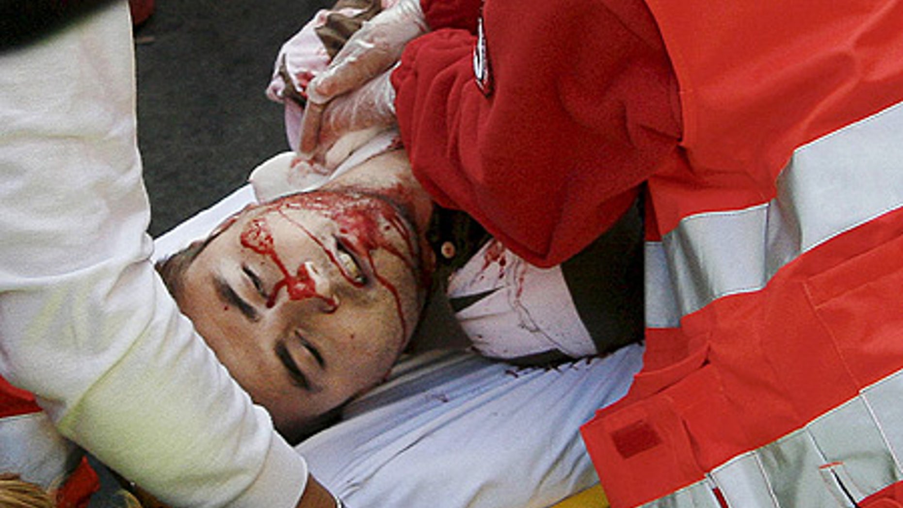 July 10: A reveler is taken away on a stretcher after being gored in the neck by a bull during the run, in Pamplona. He later died at hospital.
