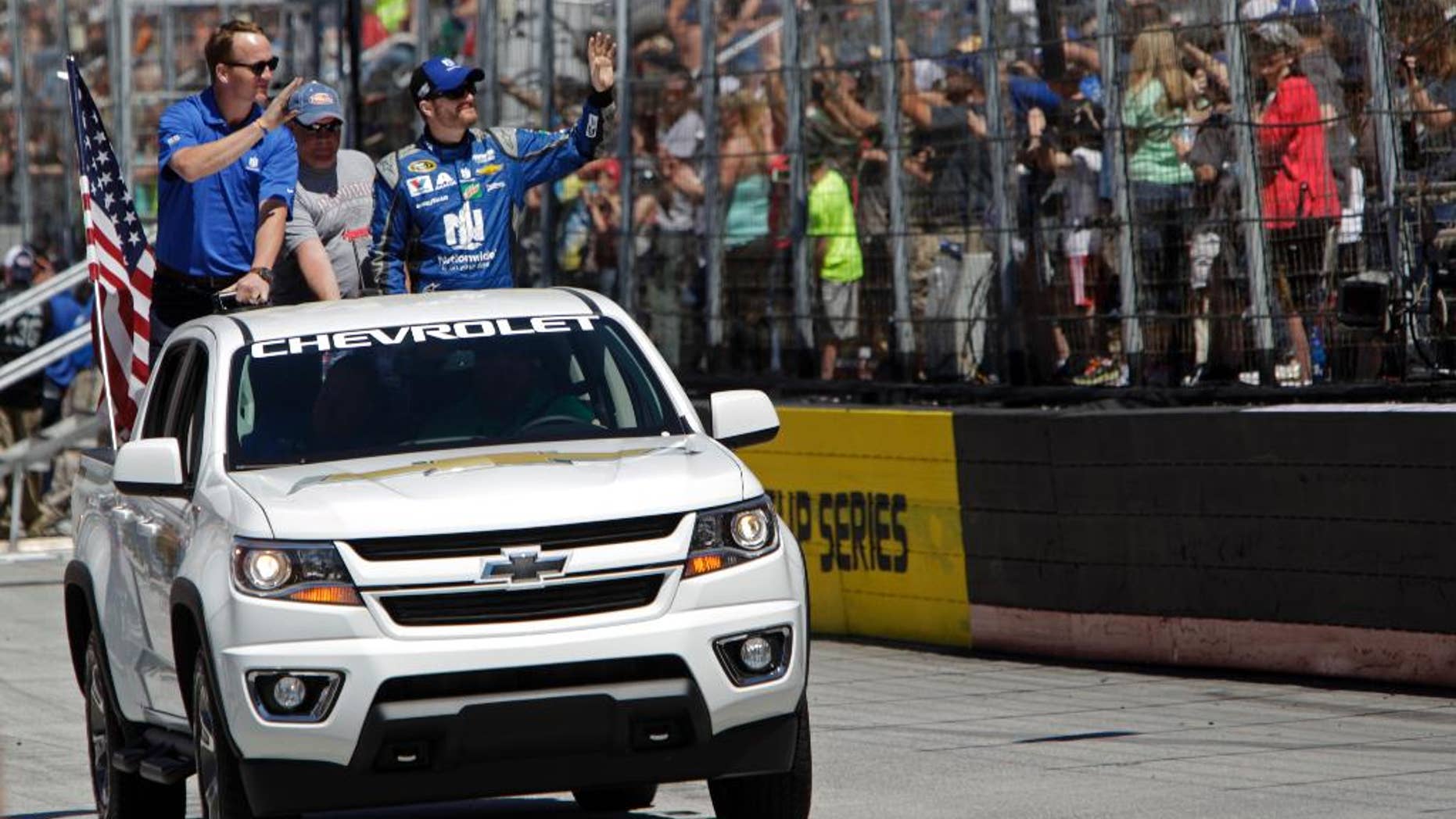 Former University of Tennessee and Denver Bronco's quarterback Peyton Manning, left, and driver Dale Earnhardt Jr. (88) wave to fans before a NASCAR Sprint Cup Series auto race, Sunday, April 17, 2016 in Bristol, Tenn. (AP Photo/Wade Payne)