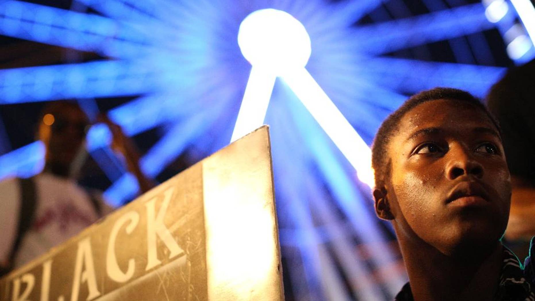 A demonstrator holds a sign during a protest in Atlanta on Friday, Sept. 23, 2016 in response to the police shooting deaths of Terence Crutch in Tulsa, Okla. and Keith Lamont Scott in Charlotte, N.C. (AP Photo/Branden Camp)