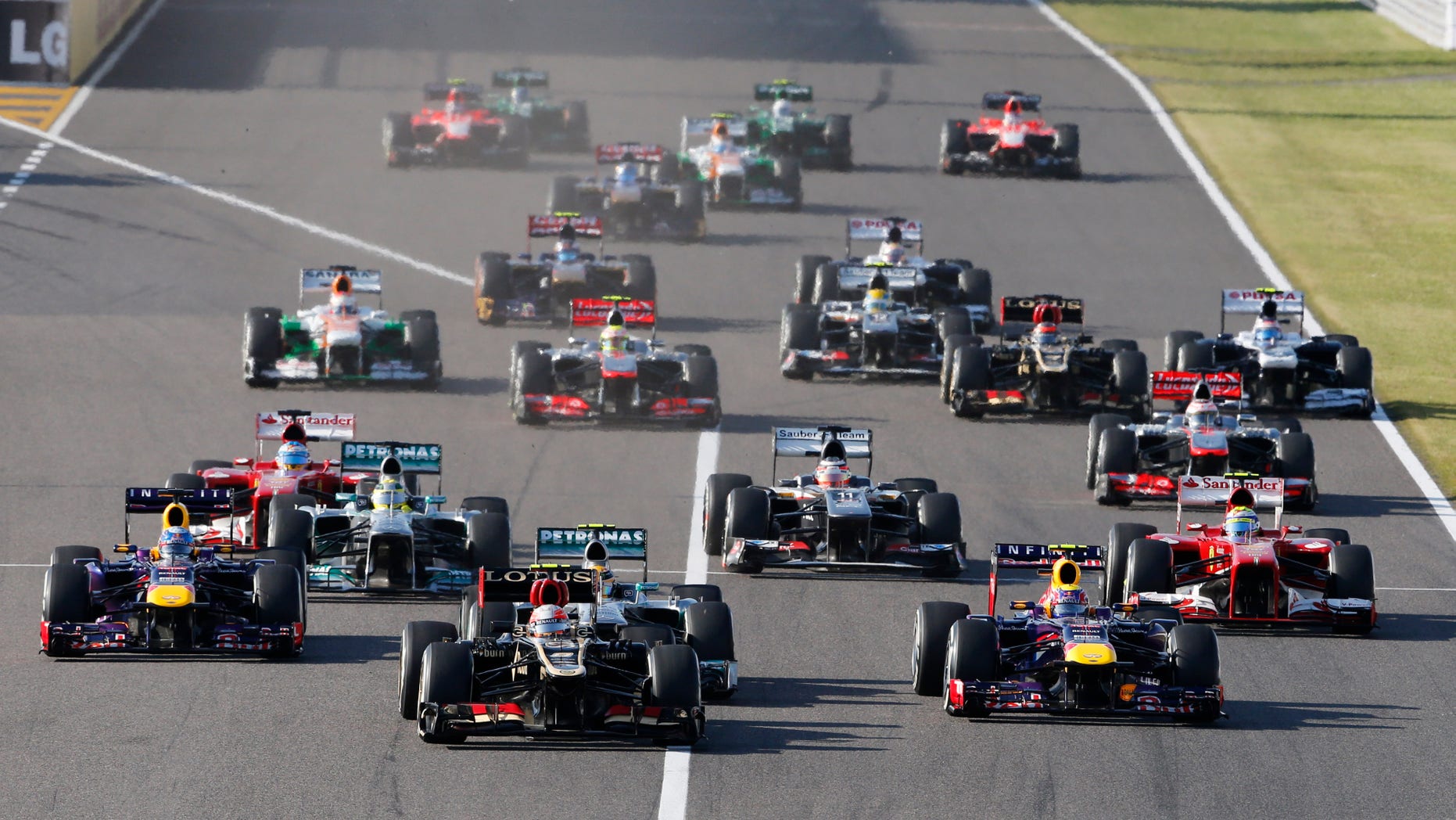 Lotus driver Romain Grosjean of France, center, leads Red Bull driver Mark Webber of Australia, front right, and Red Bull driver Sebastian Vettel of Germany, left, at the start of the Japanese Formula One Grand Prix at the Suzuka circuit in Suzuka, Japan, Sunday, Oct. 13, 2013. (AP Photo/Shuji Kajiyama)