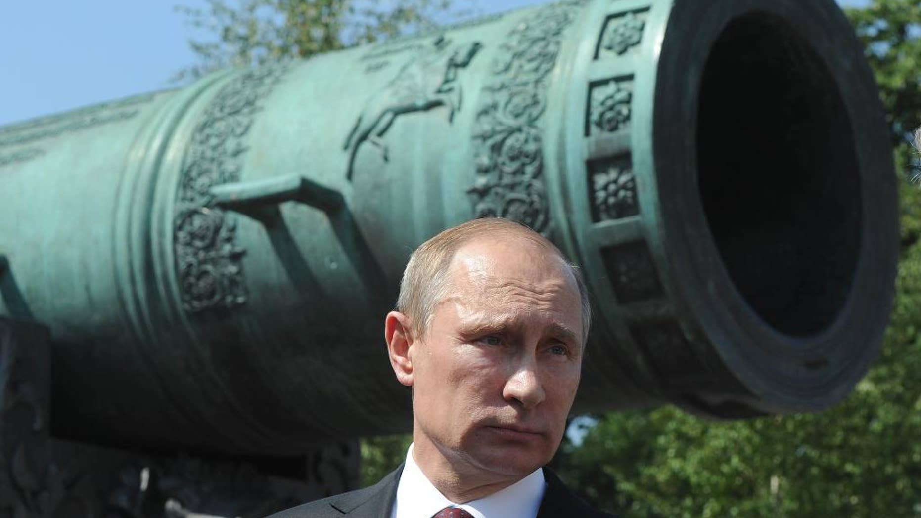 Russian President Vladimir Putin looks on during a meeting outside the Tzar Pushka ( Tzar Cannon) in Moscow's Kremlin, Russia, Thursday, July 31, 2014. Putin on Thursday presented state awards to cosmonauts, lawmakers, journalists and others. (AP Photo/RIA Novosti Kremlin, Mikhail Klimentyev, Presidential Press Service)