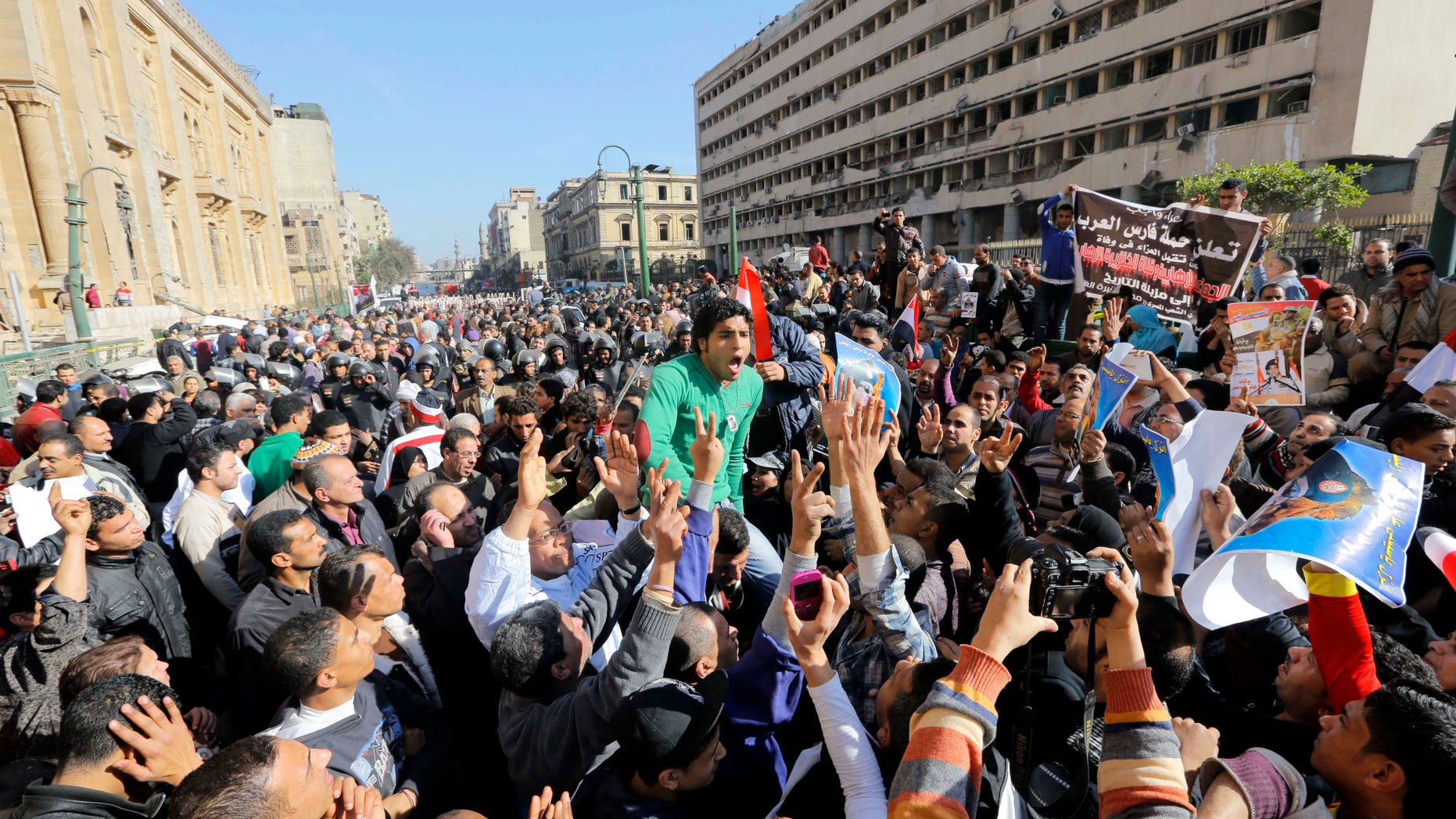 Egyptians shout anti-terrorism slogans as they demonstrate in front the site of a blast at the Egyptian police headquarters, at right, and the Museum of Islamic Art, at left, in downtown Cairo, Egypt, Friday, Jan. 24, 2014. A car bomb struck the main Egyptian police headquarters Friday in the heart of Cairo, killing several people in a hugely symbolic attack on the eve of the third anniversary of the 2011 uprising that toppled longtime autocratic ruler Hosni Mubarak. (AP Photo/Amr Nabil)