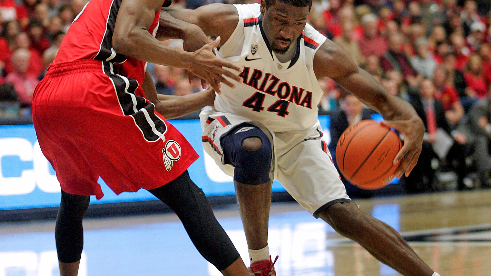 Arizona's Soloman Hill, (44) drives against the pressing defense of Utah's Jarred DuBois, left, during the first half of an NCAA college basketball game at McKale Center in Tucson, Ariz., Jan. 5, 2013. (AP Photo/John Miller)