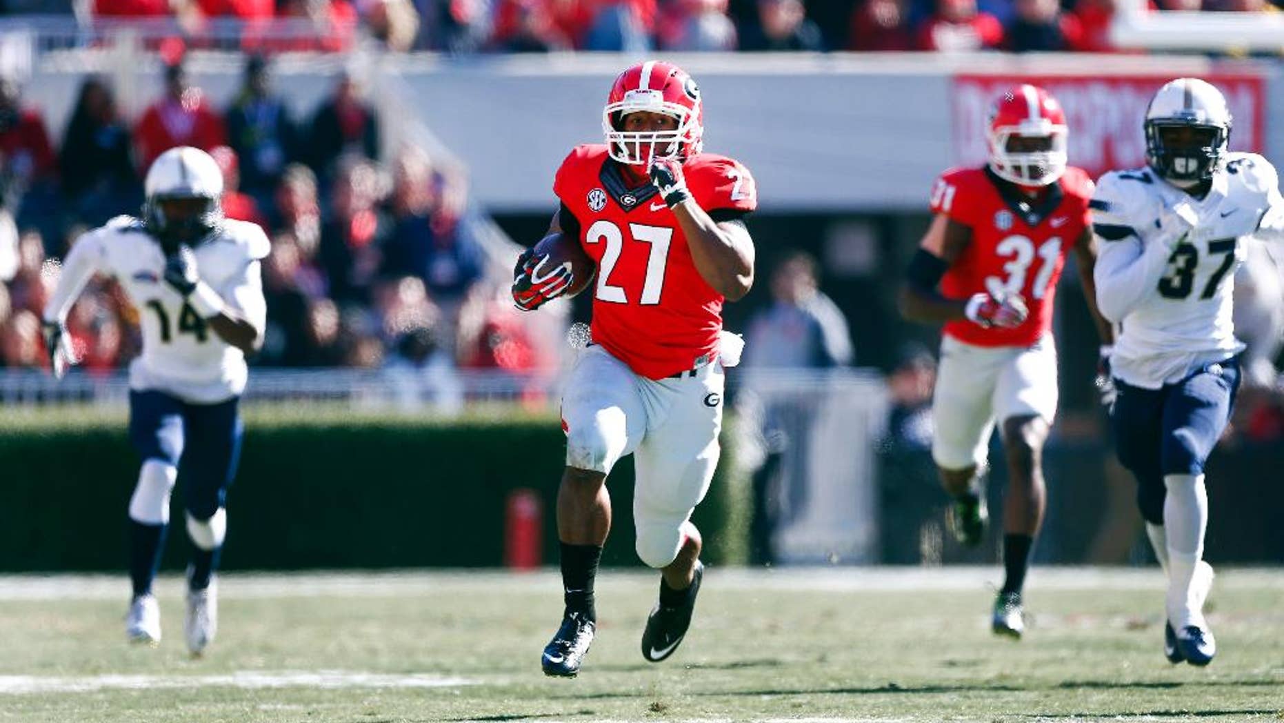 Georgia running back Nick Chubb (27) breaks free for a touchdown as Charleston Southern defensive backs Malcolm Jackson (14) and Davion Anderson (37) give chase during the first half of an NCAA college football game, Saturday, Nov. 22, 2014, in Athens, Ga. (AP Photo/John Bazemore)