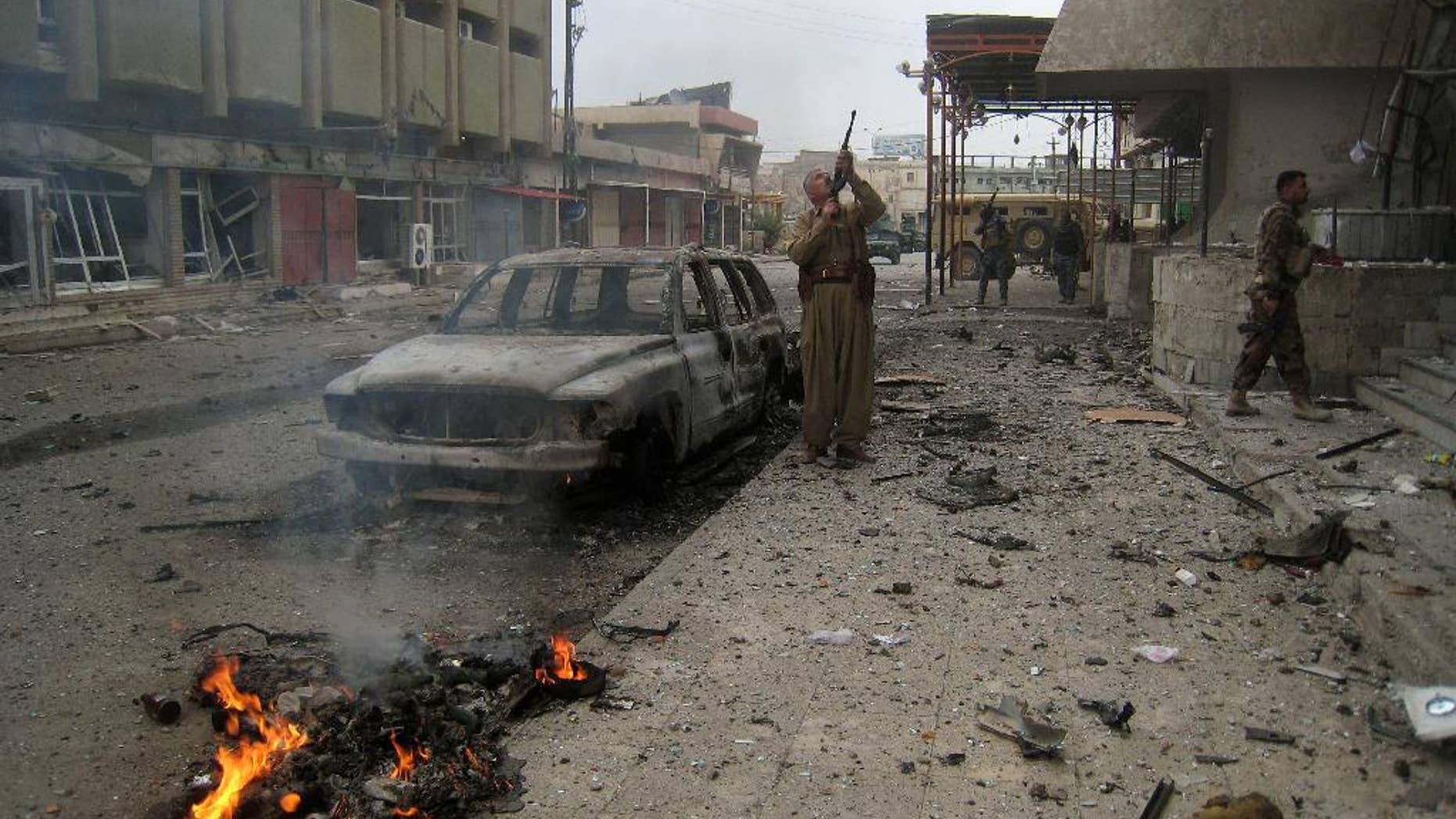 Kurdish Peshmerga fighters surround extremists inside a hotel near police headquarters in the oil-rich city of Kirkuk, 290 kilometers (180 miles) north of Baghdad, Iraq, Friday, Jan. 30, 2015. Kurdish troops and the city’s security force have been trying to rout the IS group. Three gunmen subsequently took positions inside the hotel, located in the city center, triggering a firefight with the Kurds and the police. (AP Photo)