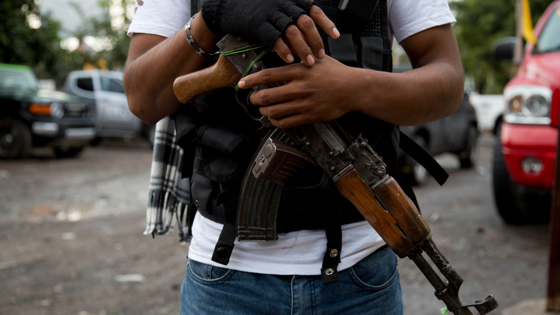 FILE - In this Jan. 16, 2014 file photo, an armed man belonging to the Self-Defense Council of Michoacan, (CAM), stands guard at a checkpoint set up by the self-defense group at the entrance to Antunez, Mexico. Mexico essentially legalized the country’s growing “self-defense” groups Monday, Jan. 27, 2014, while also announcing that security forces had captured one of the four top leaders of the Knights Templar drug cartel, which the vigilante groups have been fighting for the last year. The government said it had reached an agreement with vigilante leaders to incorporate the armed civilian groups into old and largely forgotten quasi-military units called the Rural Defense Corps. (AP Photo/Eduardo Verdugo, File)