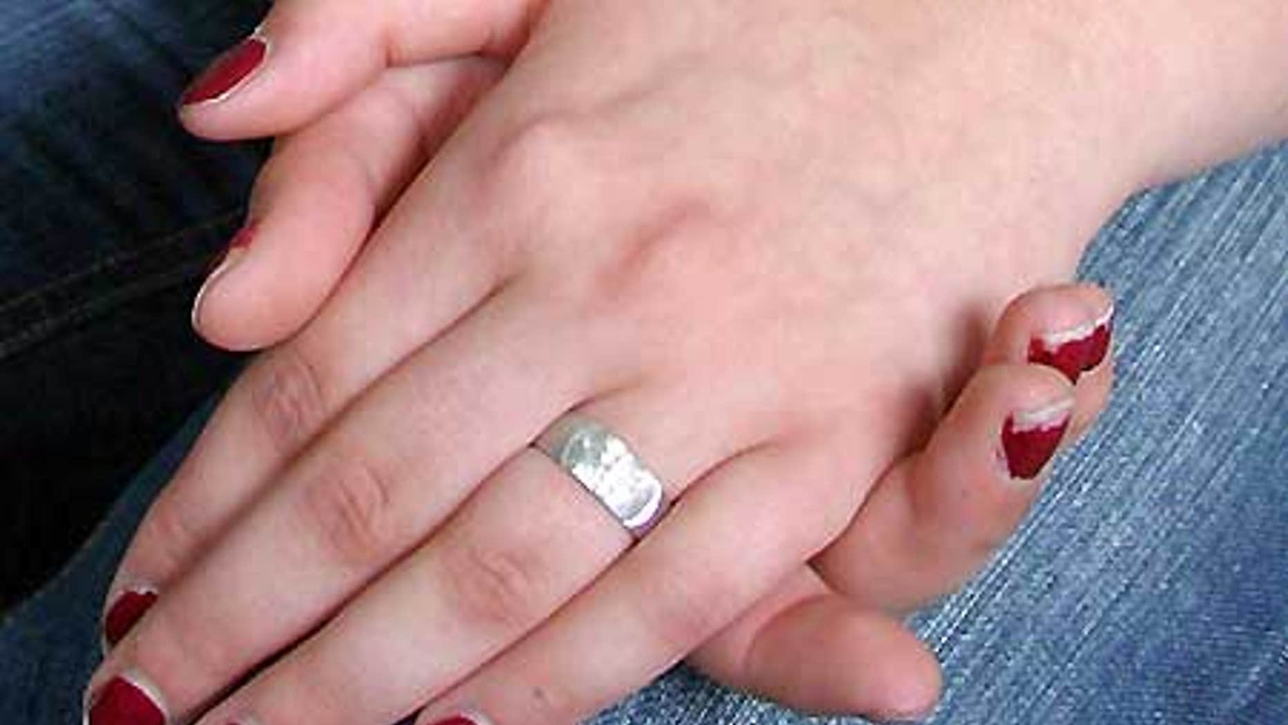 A teenaged girl wears a purity ring representing her pledge to remain celibate until marriage.