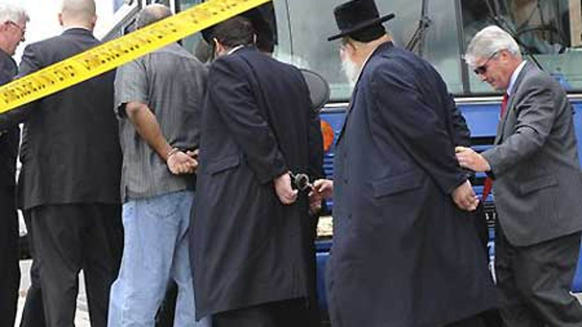 July 23: FBI agents lead arrested suspects from their headquarters as part of a corruption investigation in Newark, N.J.