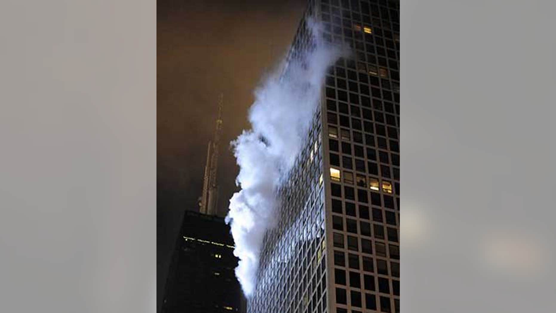 Dec. 10: Smoke pours from a fire on the 36th floor of a high-rise condo building near the John Hancock Center (left).